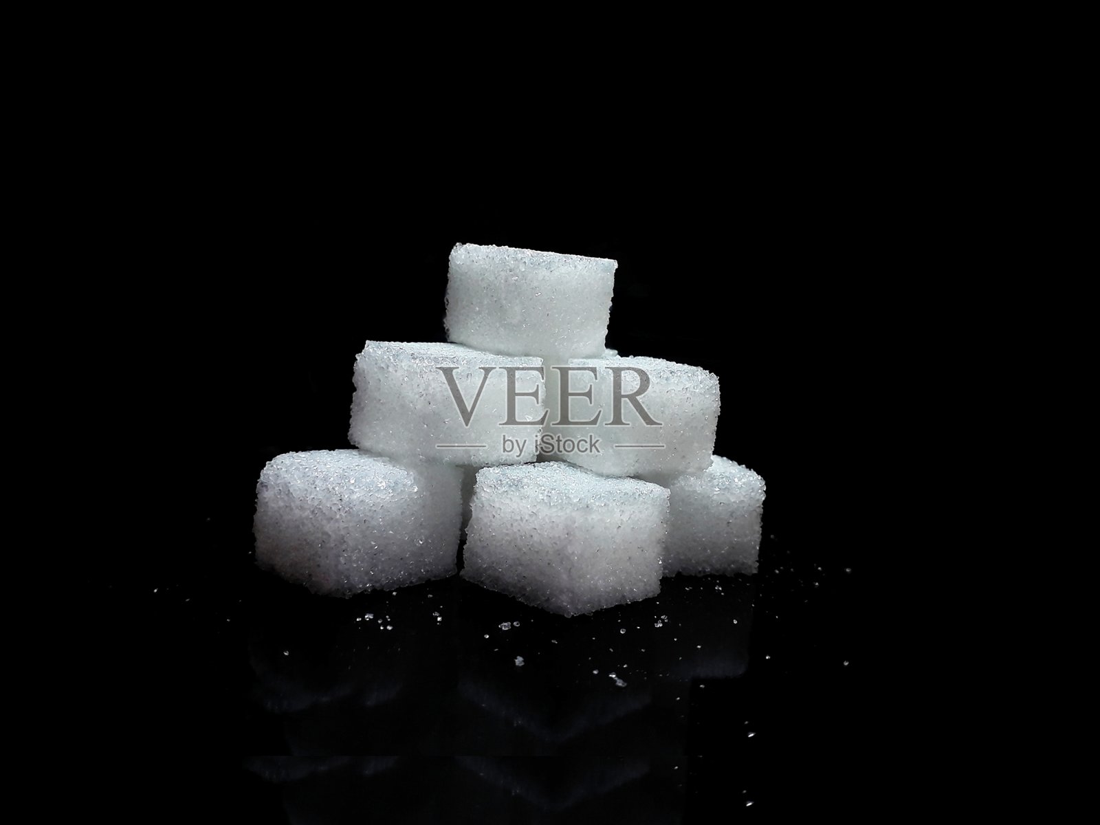 黑色背景上的方糖块，孤立的白糖块照片摄影图片