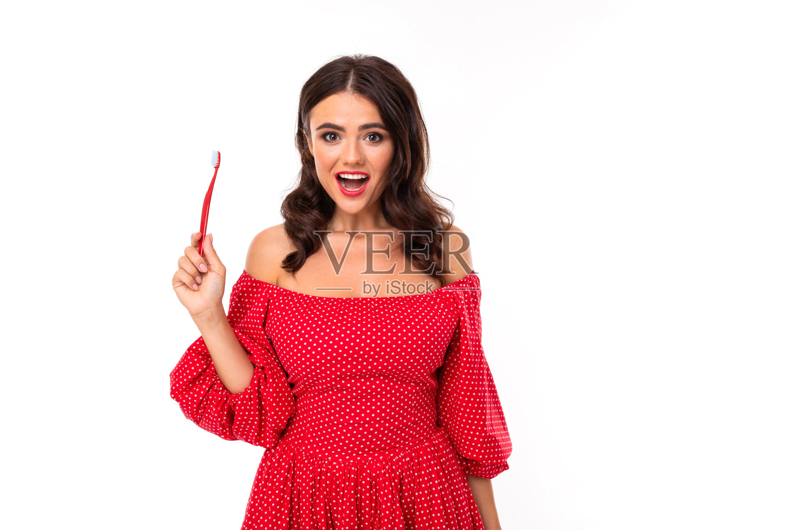 一个漂亮的白人女孩的肖像，拿着一把牙刷孤立在白色的背景上照片摄影图片