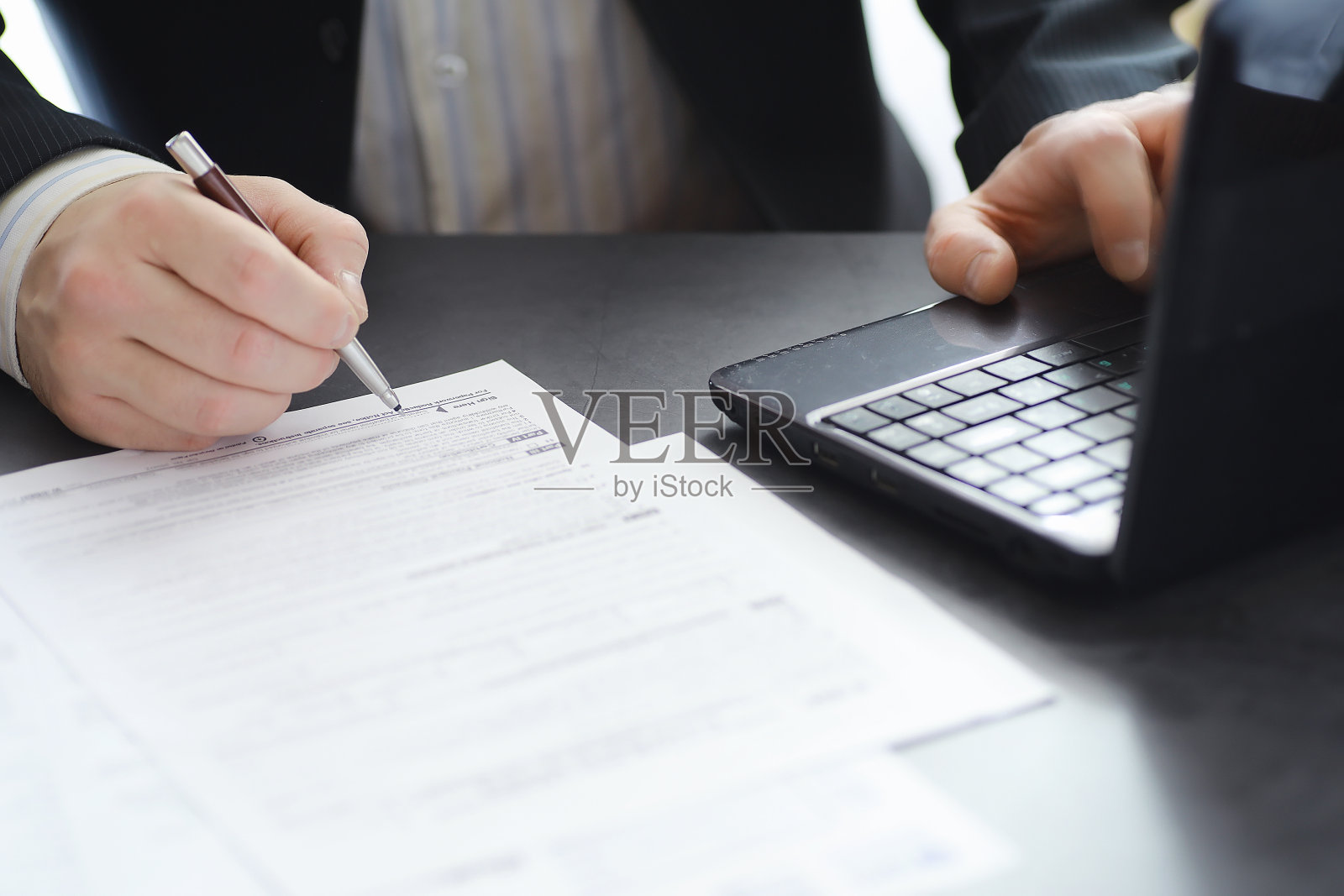 经理在办公室用笔记本电脑工作。商人进行网上交易。通过互联网在交易所进行交易。照片摄影图片