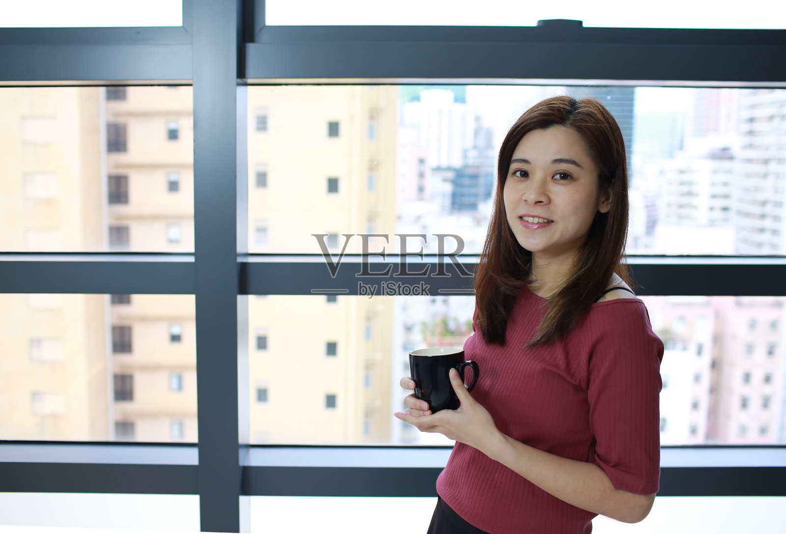 在窗边拿着热饮的女孩照片摄影图片