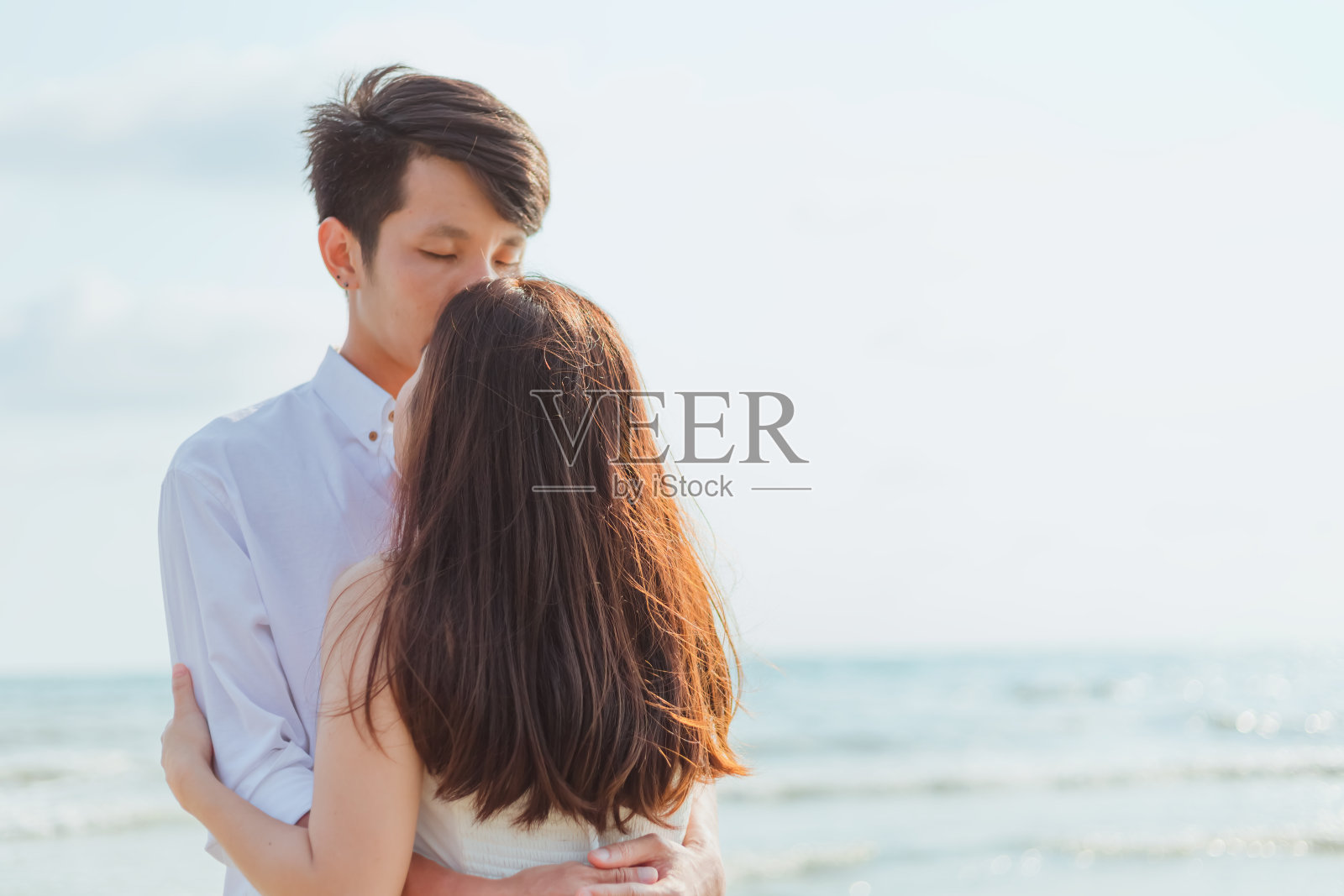 浪漫时刻：情侣在海滩上亲吻，爱之旅照片摄影图片