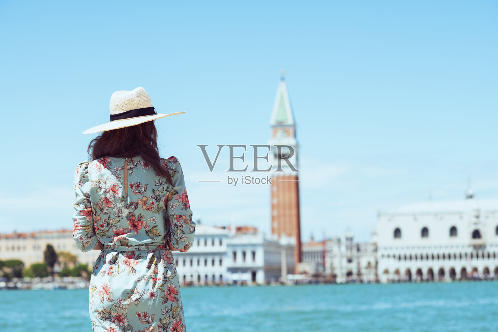 从后面看到一个穿着碎花连衣裙的女人正在散步照片摄影图片