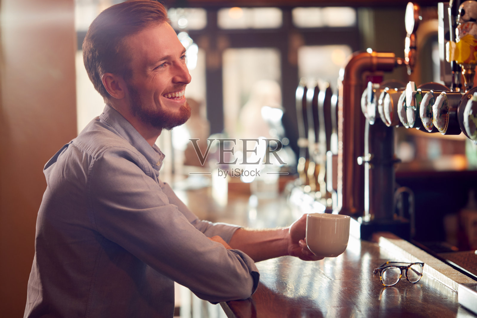 男老板或酒吧经理坐在柜台喝咖啡照片摄影图片
