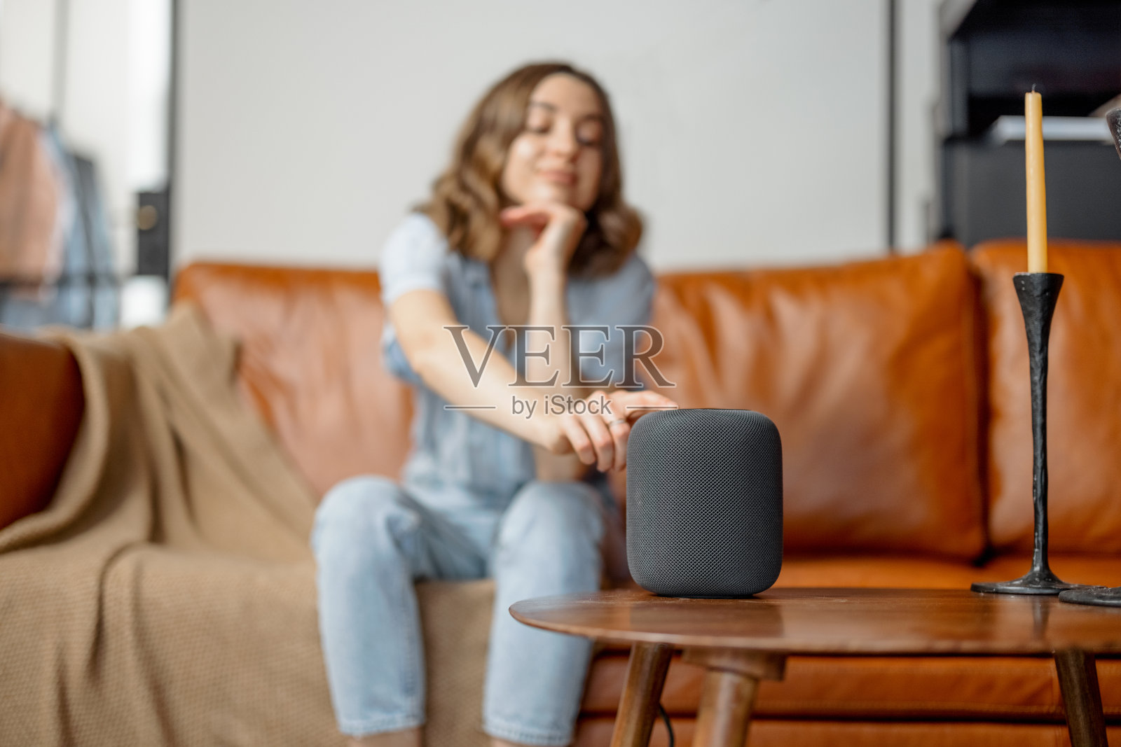 女人触摸着咖啡桌上的黑色音频助手栏照片摄影图片