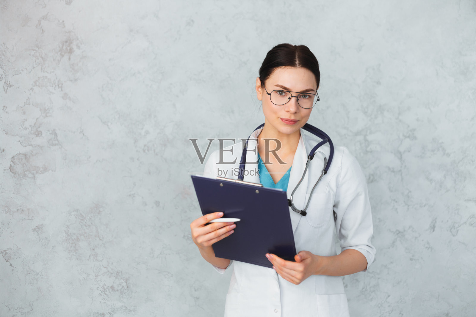 年轻女医生与听诊器和文件夹。白种人的头发照片摄影图片