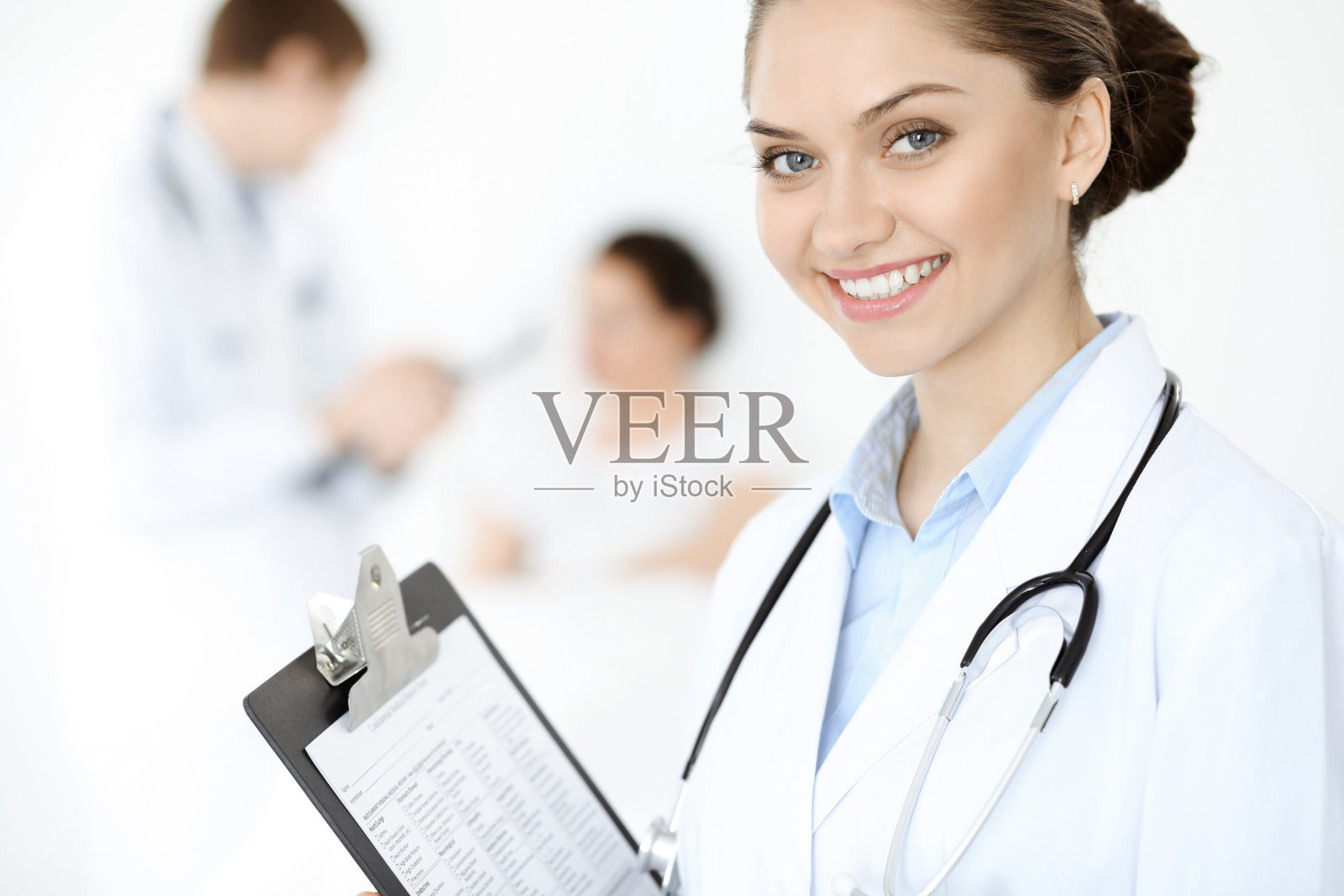 他的病人躺在床上，他身后是一位面带微笑的女医生。医学的概念照片摄影图片