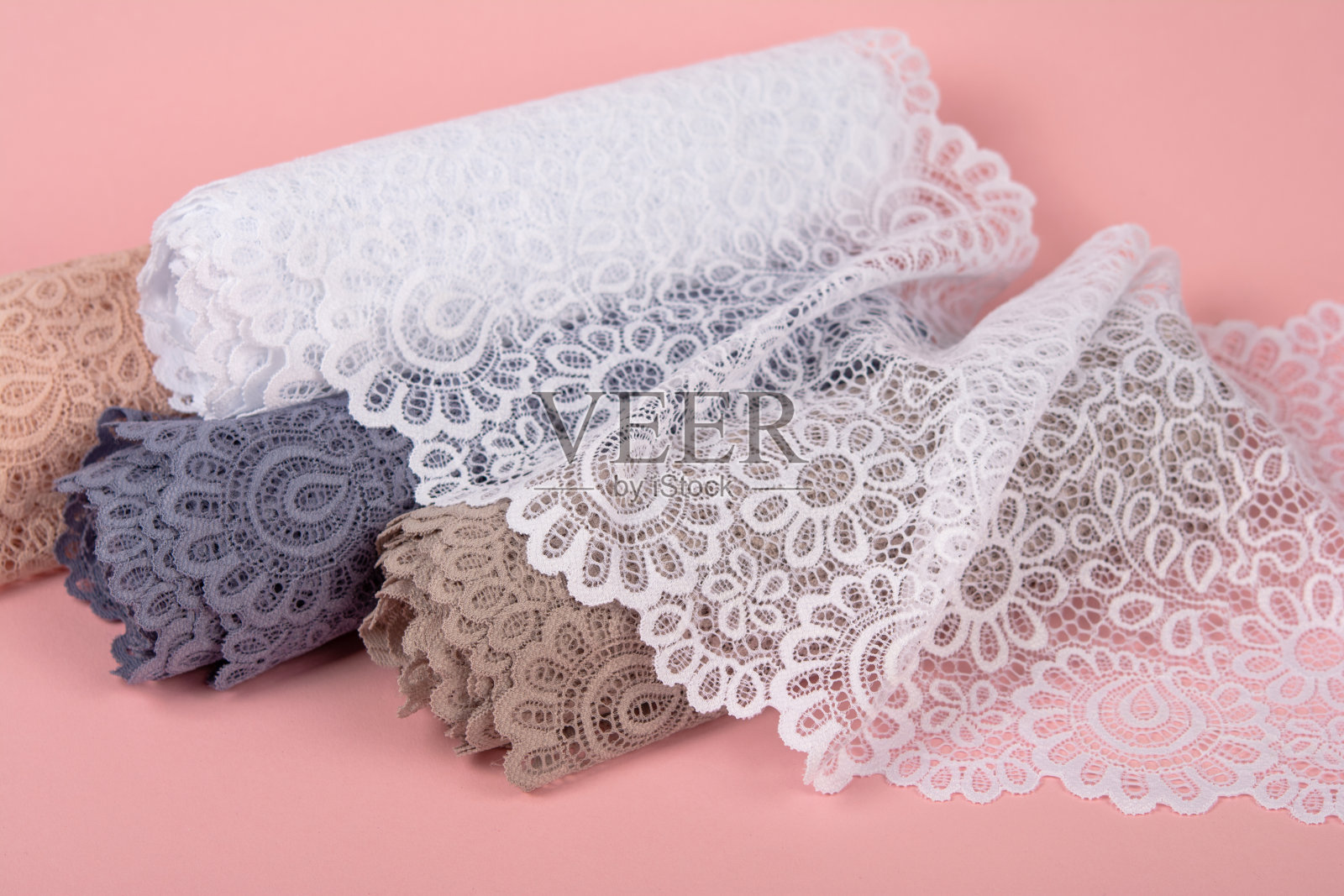 精致的蕾丝卷内裤和胸罩在粉红色的背景与塑料配件。弹性材料。用于Atelier和布料商店。照片摄影图片
