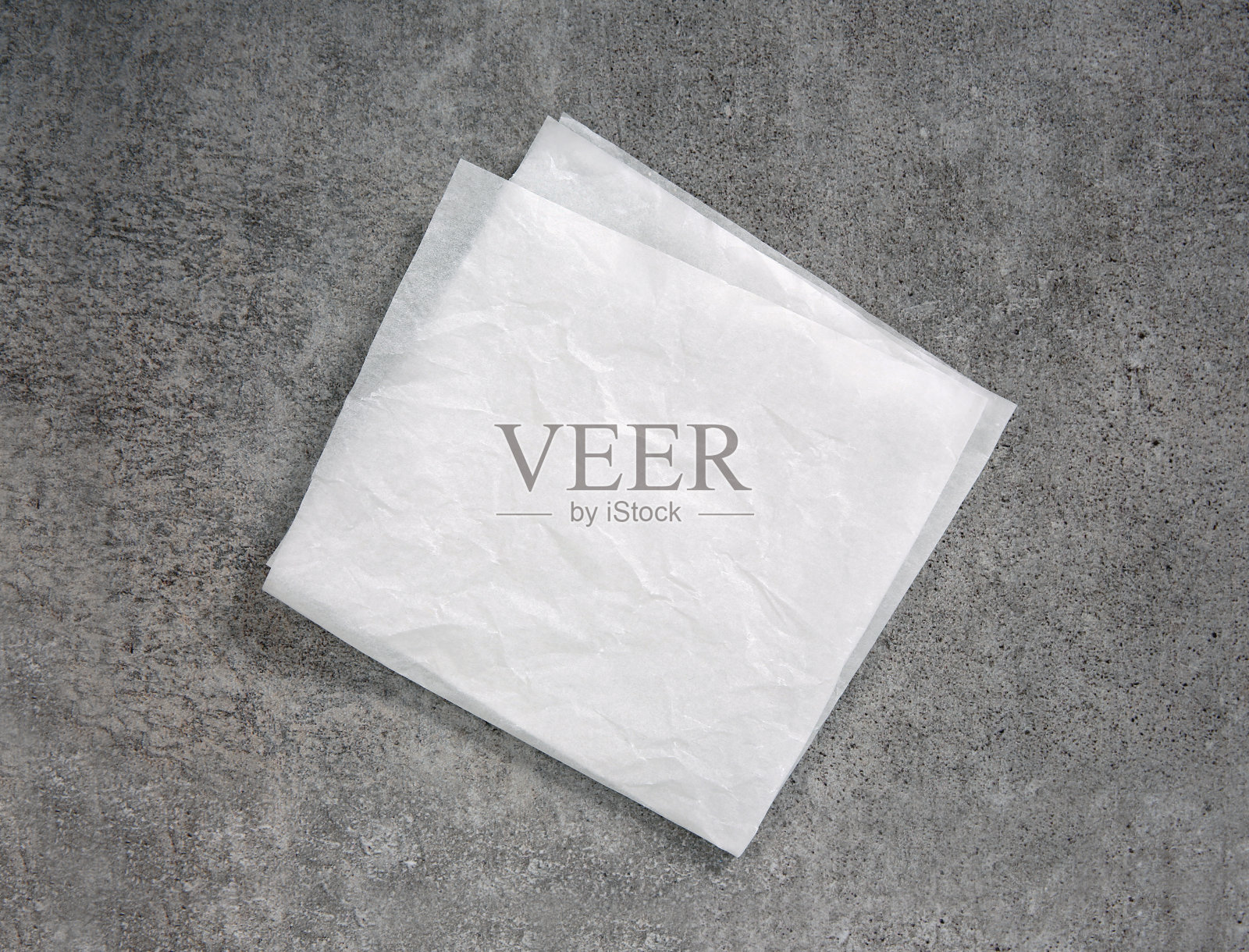 白色皱巴巴的方形纸，餐巾俯视图放在桌上。食品广告设计。厨房用纸平铺。照片摄影图片