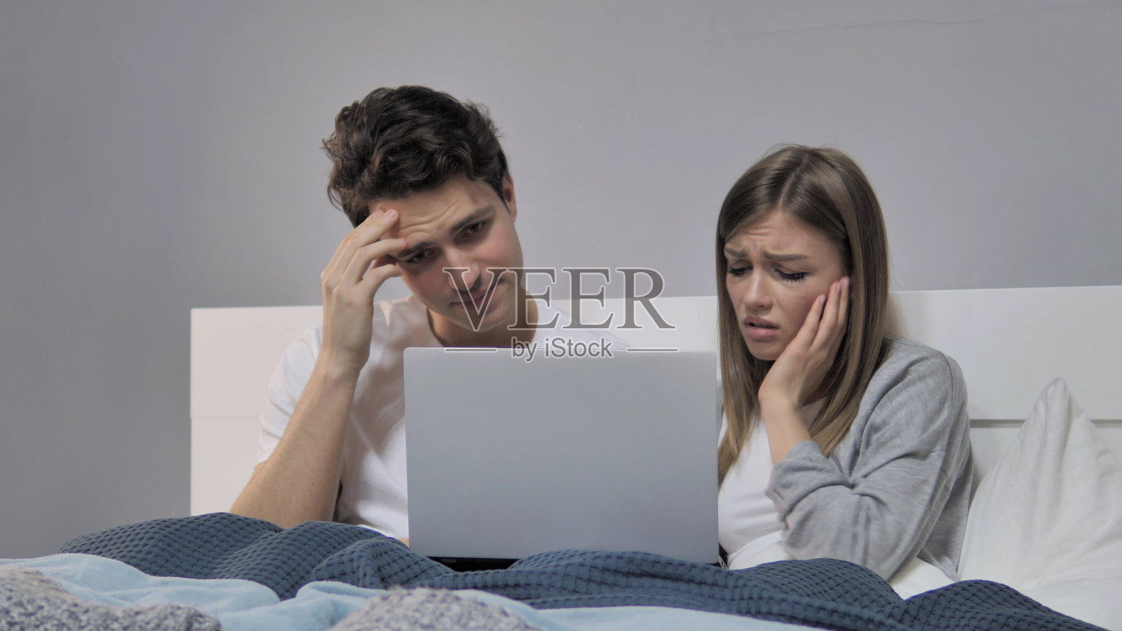 网上的损失，床上的年轻夫妇对失败的反应照片摄影图片