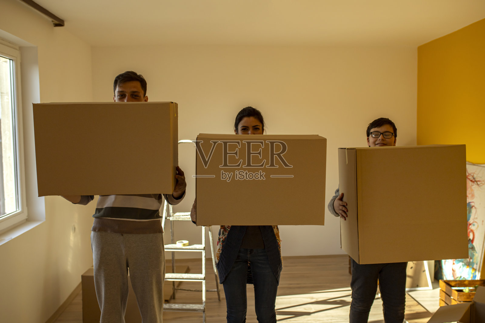 三个人站成一排拿着箱子照片摄影图片