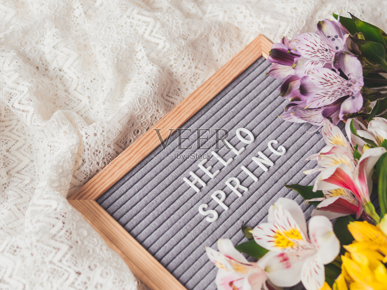 信板与季节问候你好春天花边白色纺织背景与新鲜的紫花。照片摄影图片