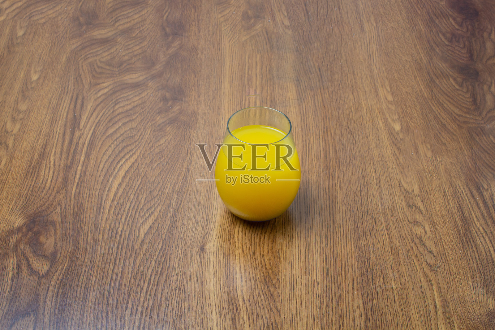 橘子汁或芒果汁装在优雅的玻璃杯里，放在木板上照片摄影图片