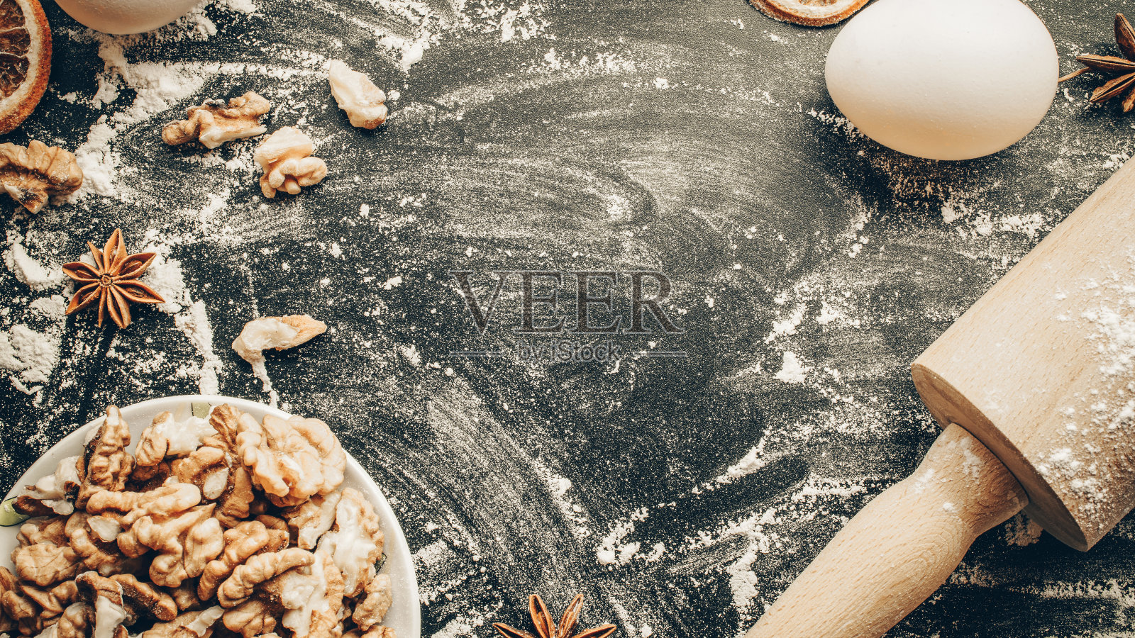 面包店组成。烹饪食物配料:面粉，鸡蛋，坚果和八角，橙色在黑暗的餐桌厨房背景蛋糕。俯视图拷贝空间。饼干、派或蛋糕食谱模型。照片摄影图片