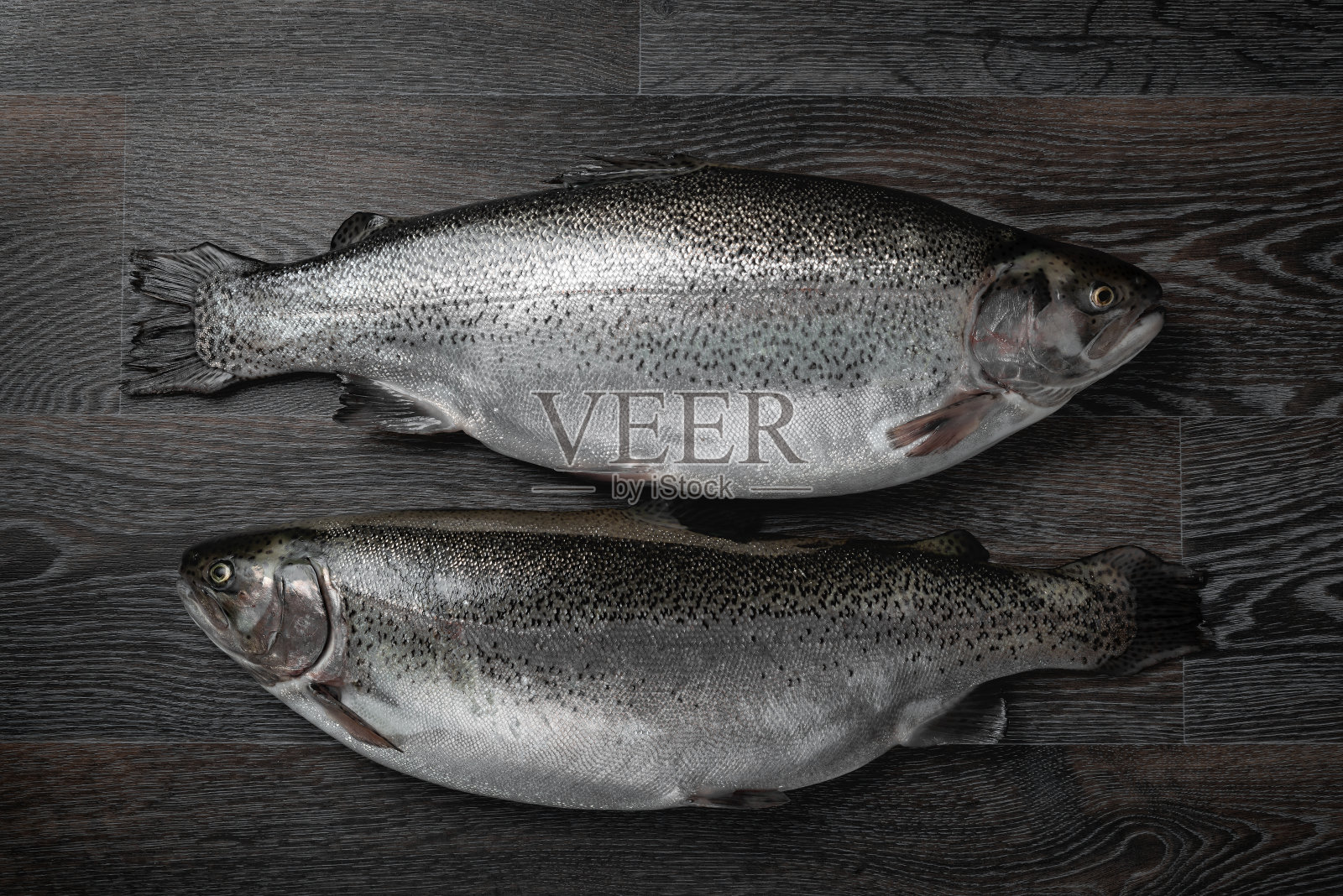 木桌上放着新鲜的生鲑鱼和红鱼。创意布局做成鱼，海鲜，俯视图，平铺照片摄影图片