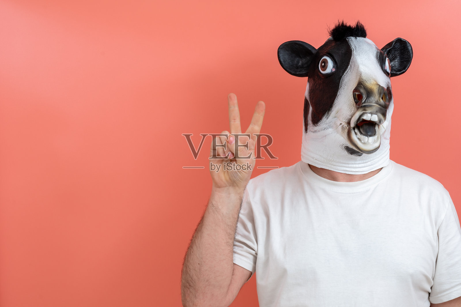 戴着牛面具做胜利手势的人照片摄影图片