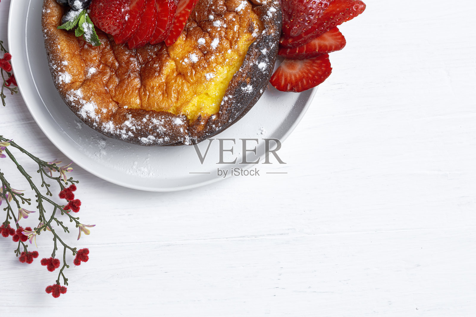 自制芝士蛋糕，上面有蓝莓、醋栗、草莓和薄荷叶。平躺照片摄影图片