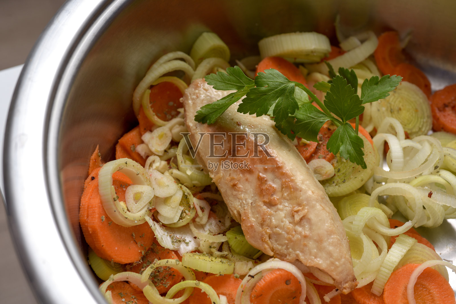 切成薄片的胡萝卜，鸡肉，欧芹和韭菜撒上香料照片摄影图片