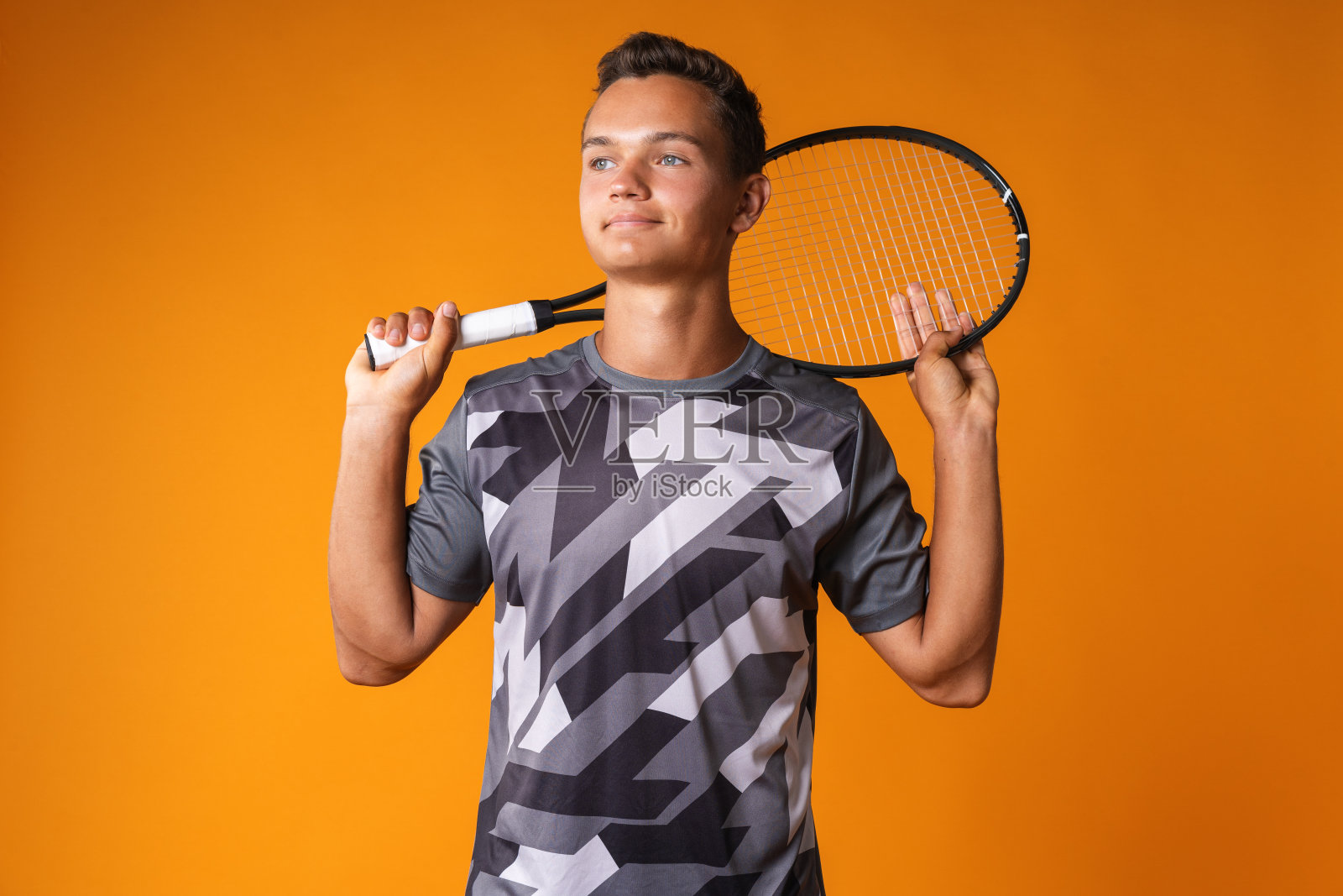 一个年轻男子网球运动员的肖像在橙色的背景照片摄影图片