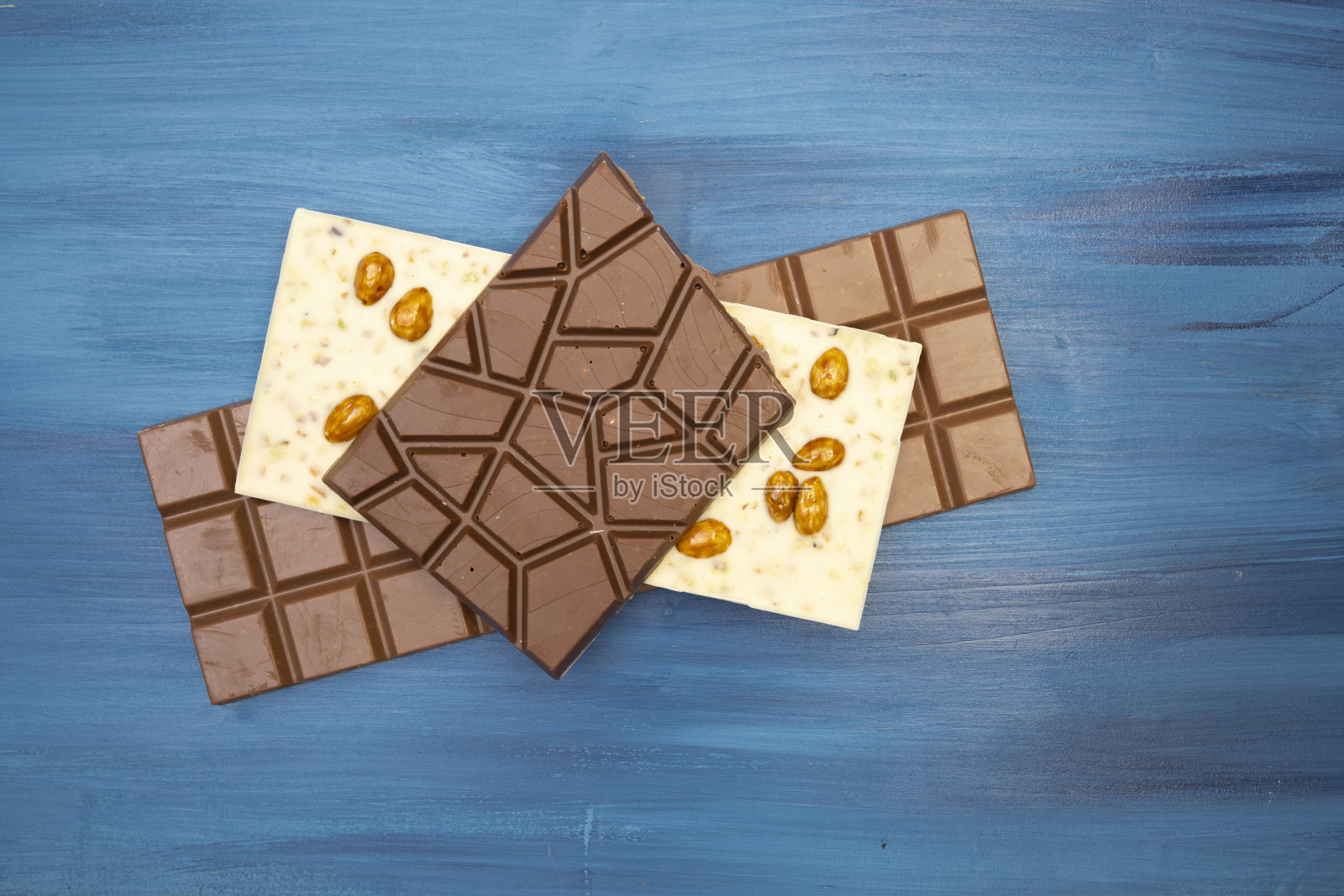 许多不同的美味巧克力棒在蓝色的背景照片摄影图片