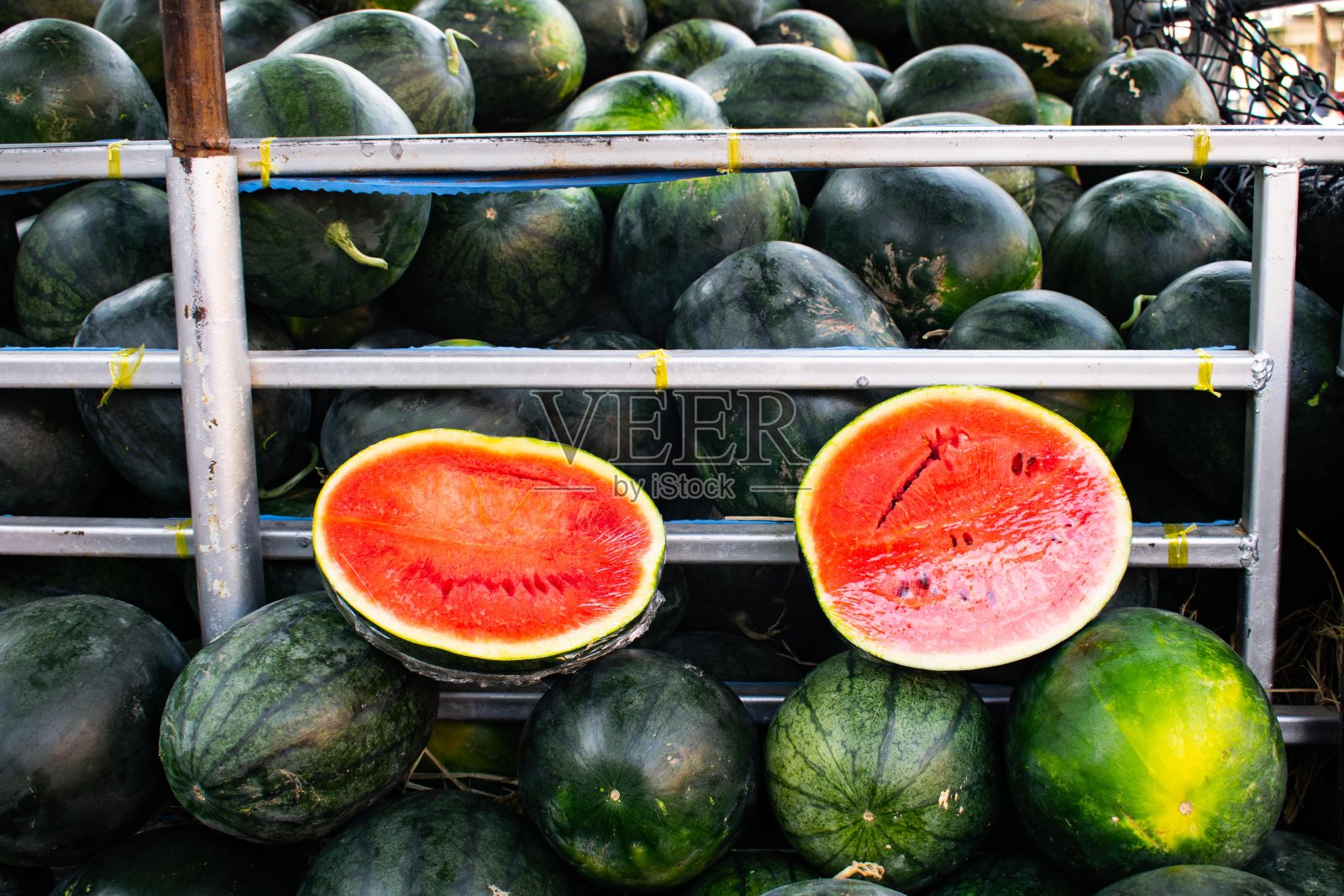 几个西瓜被切成两半。漂亮的红颜色吃。照片摄影图片