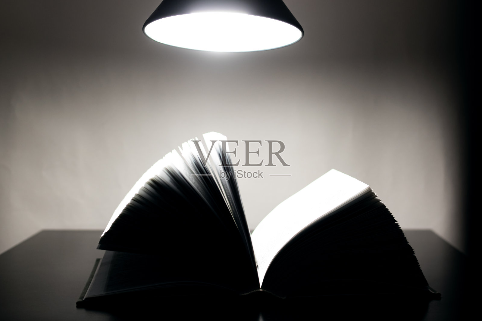 在黑暗中打开台灯上的书照片摄影图片