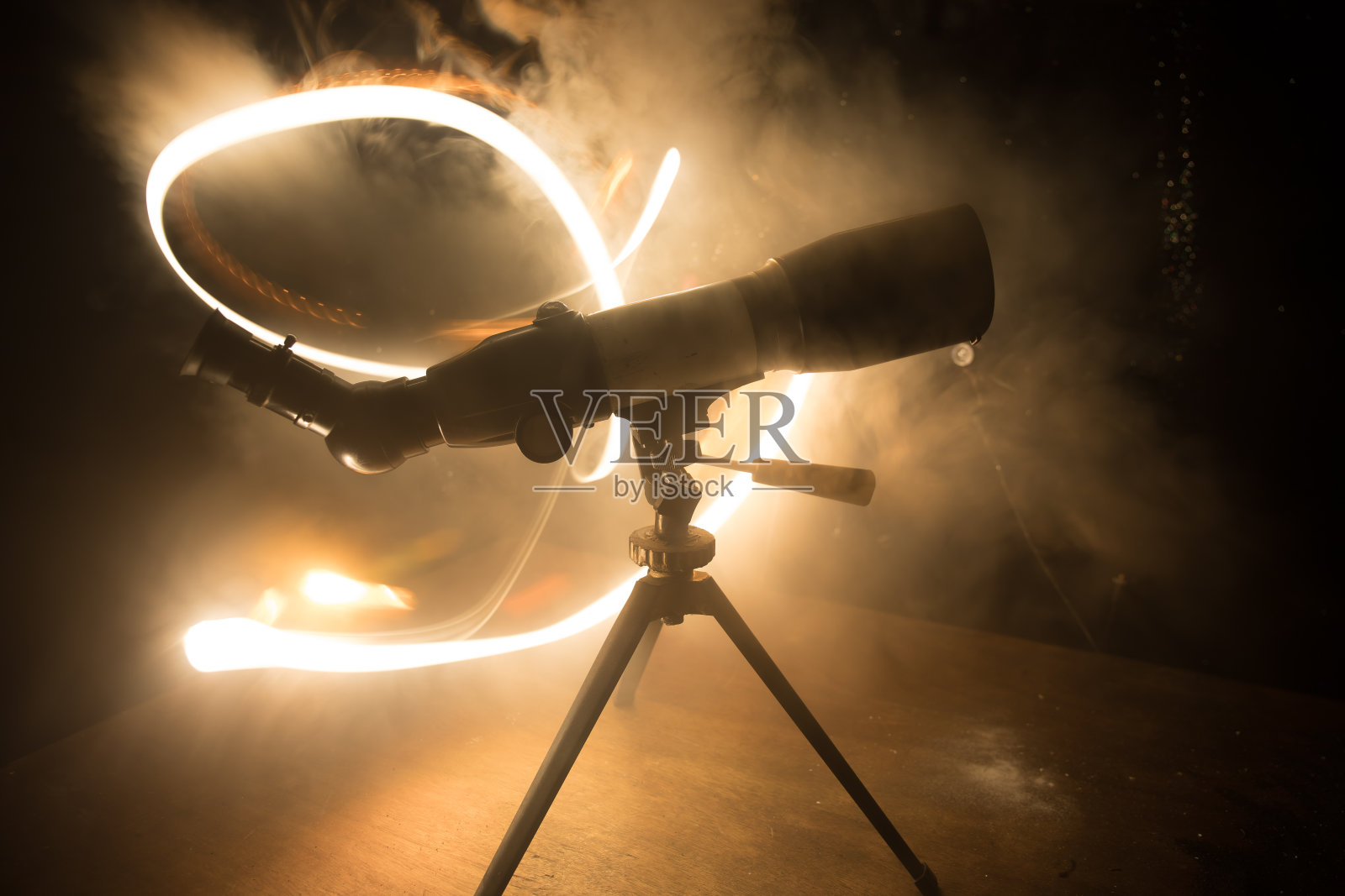 黑暗的雾状背光上天文望远镜的剪影。照片摄影图片