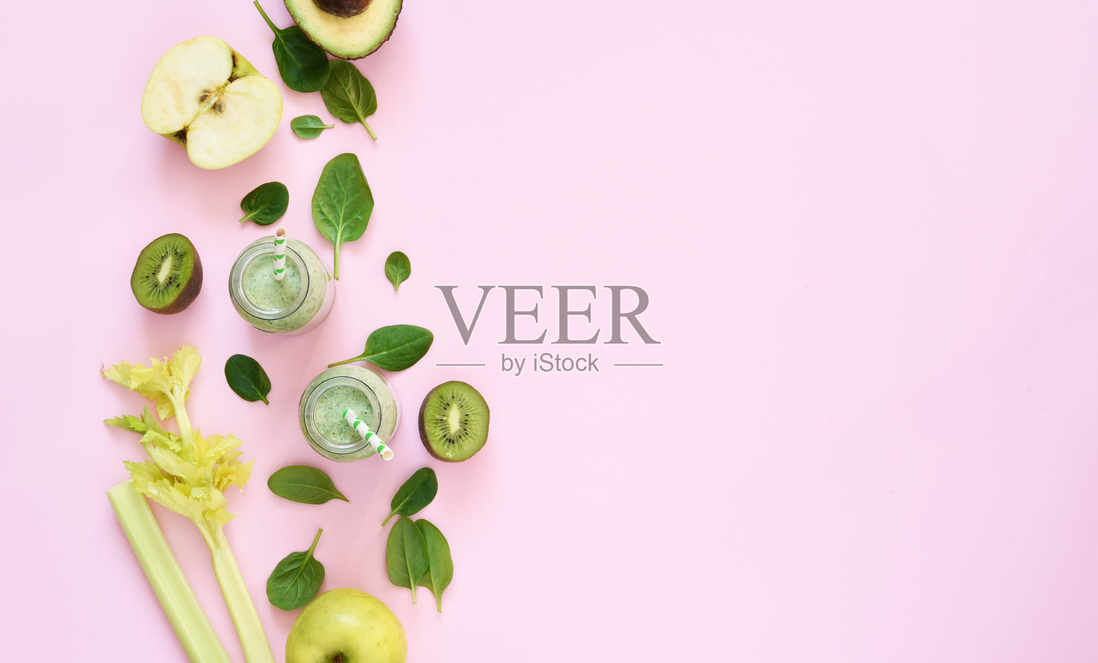 粉红背景的菠菜和苹果蔬菜奶昔。广告。排毒饮料。酮饮食。照片摄影图片