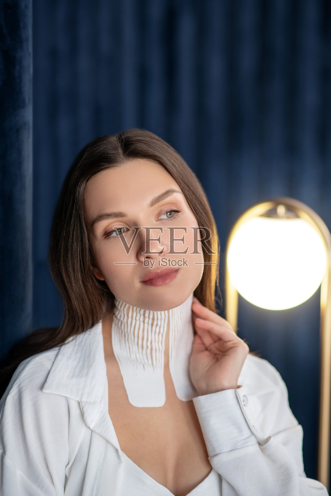 脖子上缠着带子的漂亮女人，看上去若有所思照片摄影图片