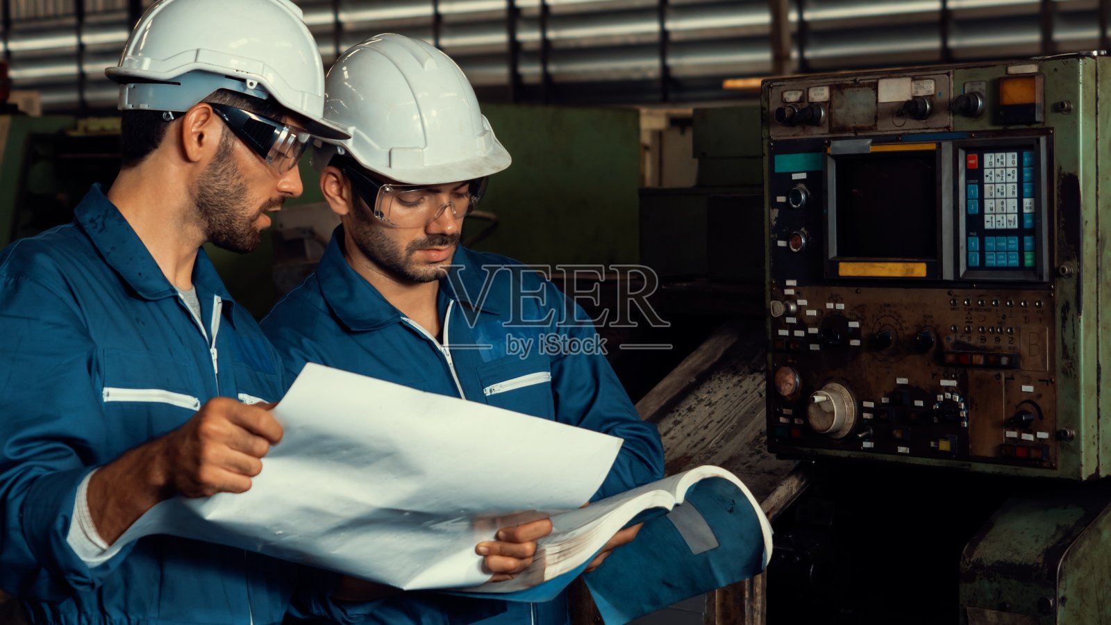 一群熟练的工厂工人在车间使用机器设备照片摄影图片