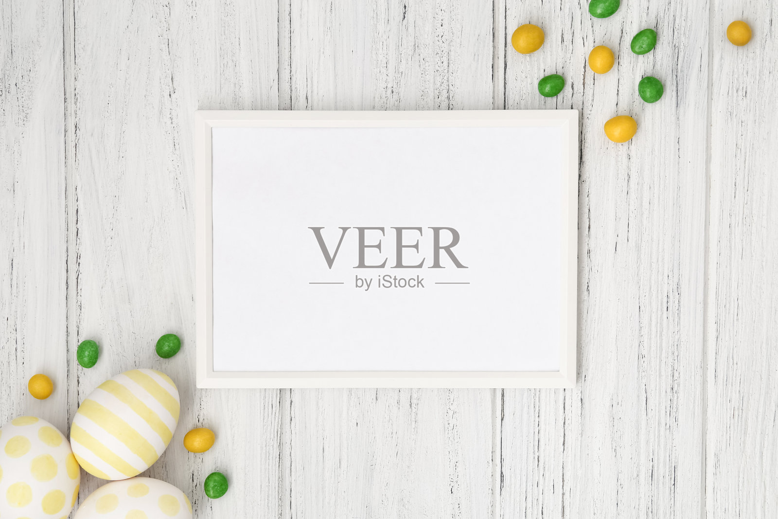 复活节的架子上放着五颜六色的鸡蛋、糖果和拷贝空间，平铺在白色的木桌上。模板,模型照片摄影图片