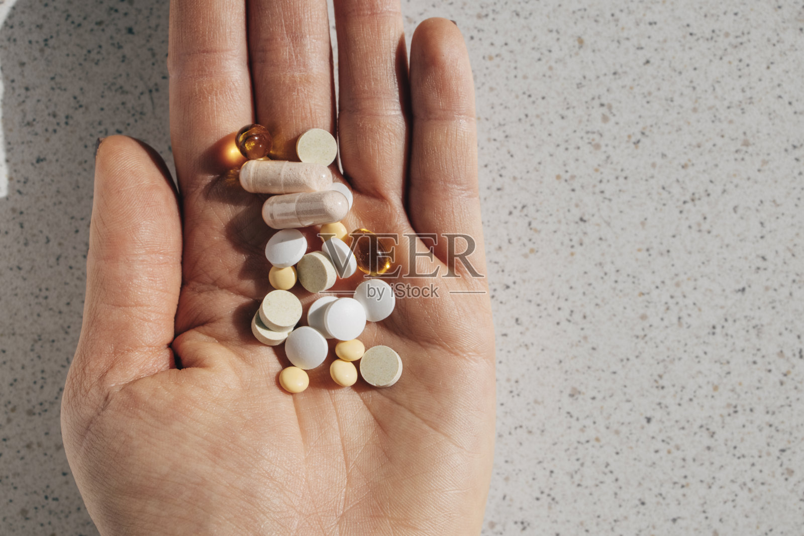 一把各种各样的药片和药丸，一个高角度拍摄一个不认识的人的手照片摄影图片