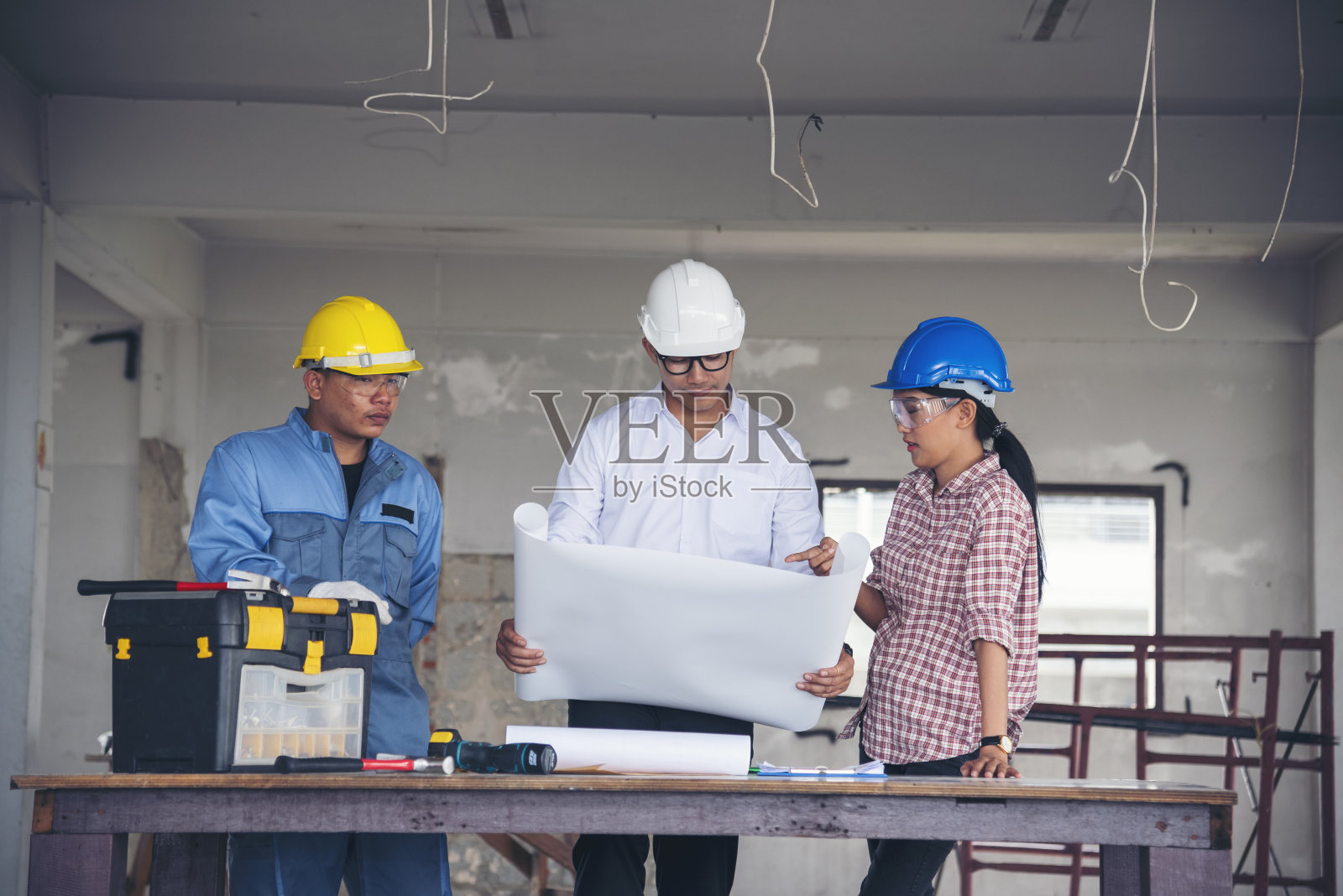 施工工程师团队安全服信托团队手持黄白安全帽在施工现场安全设备。安全帽保护头土木建筑工程师概念照片摄影图片