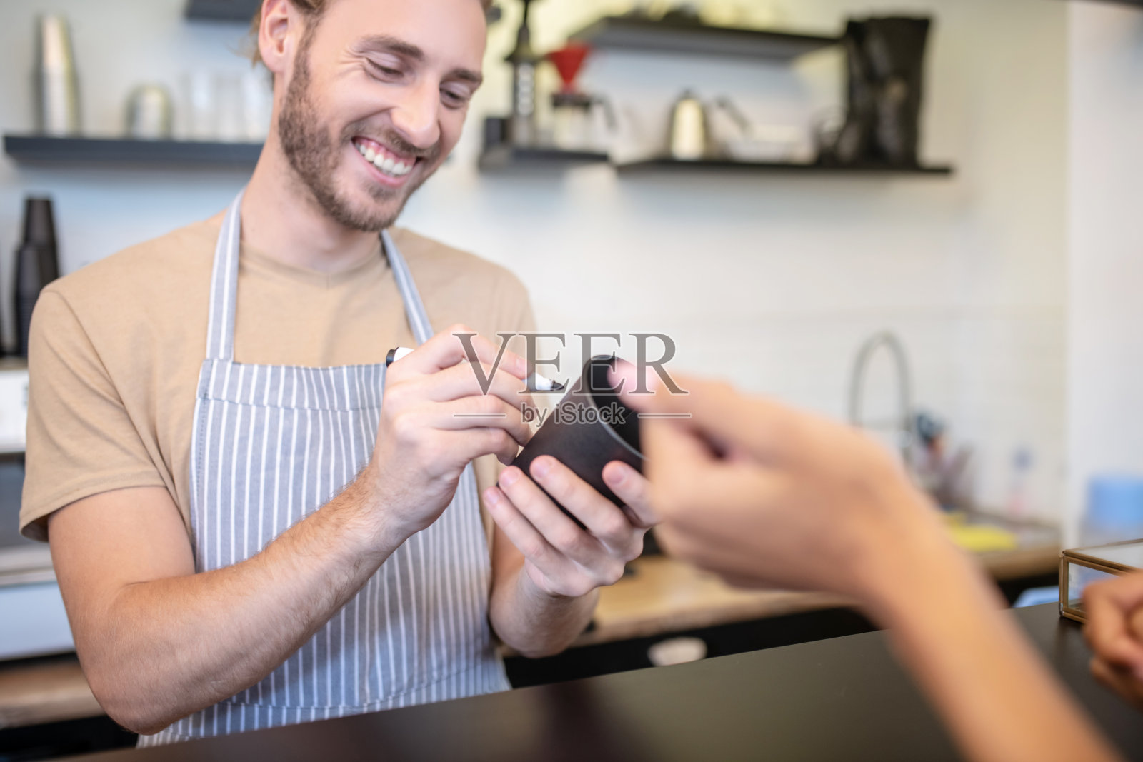 微笑的男人在围裙上用记号笔写在玻璃上照片摄影图片