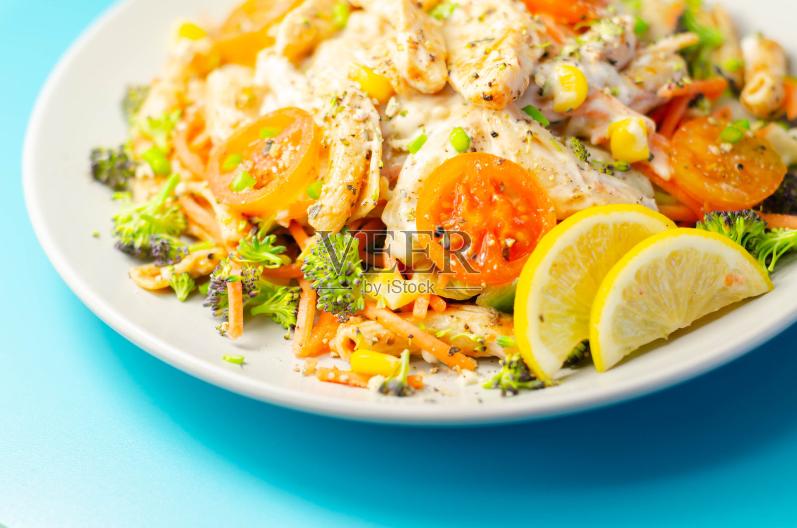 皮里皮里风格的鸡肉配上全麦意面和蔬菜，配上冷酸奶油和韭菜调味汁，照片摄影图片