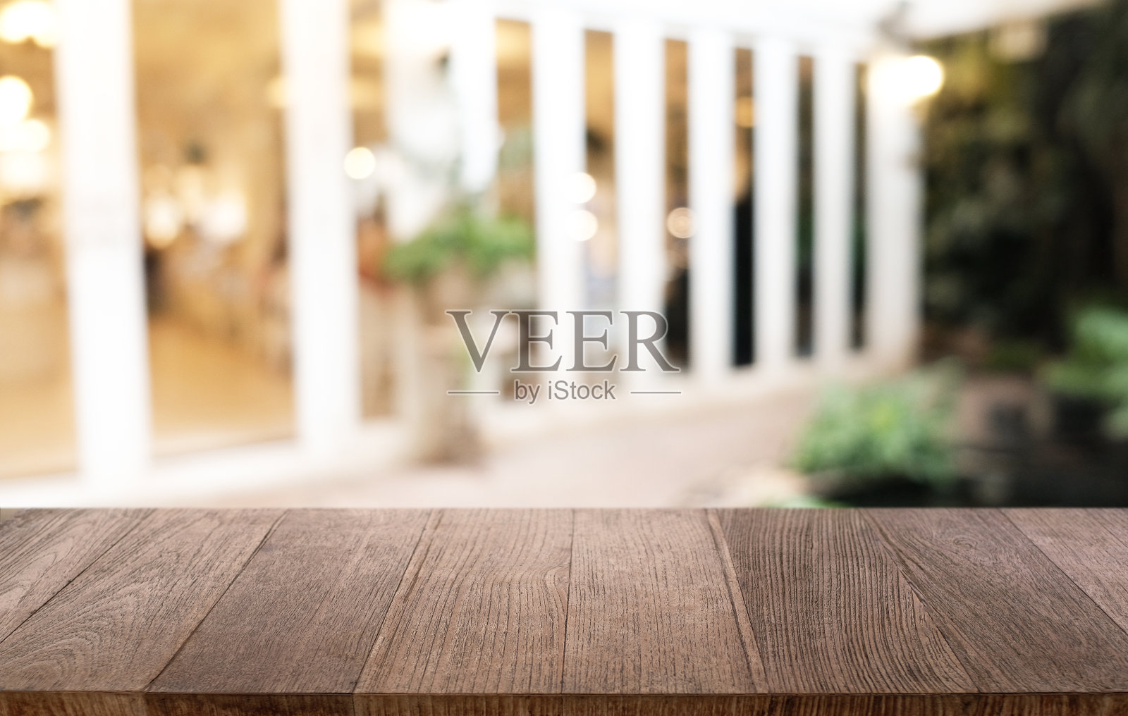 空荡荡的深色木桌前面抽象模糊的散景餐厅背景。可用于展示或蒙太奇您的产品。模拟空间。照片摄影图片