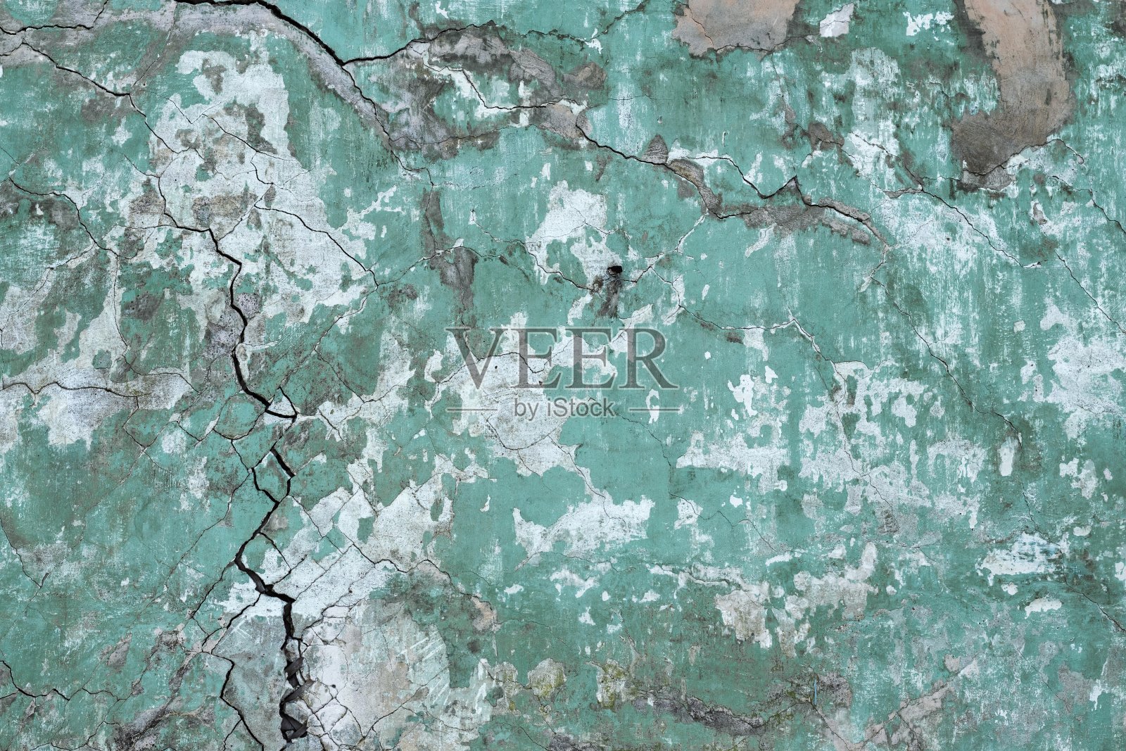 背景纹理的墙壁与旧开裂的绿色石膏。照片摄影图片