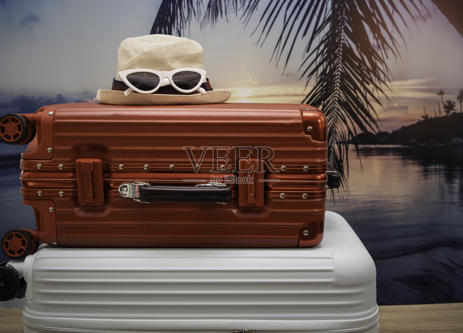 两个旅行箱作为太阳眼镜在夕阳的背景下，这是人们在夏季生活方式中的长假旅行理念。照片摄影图片