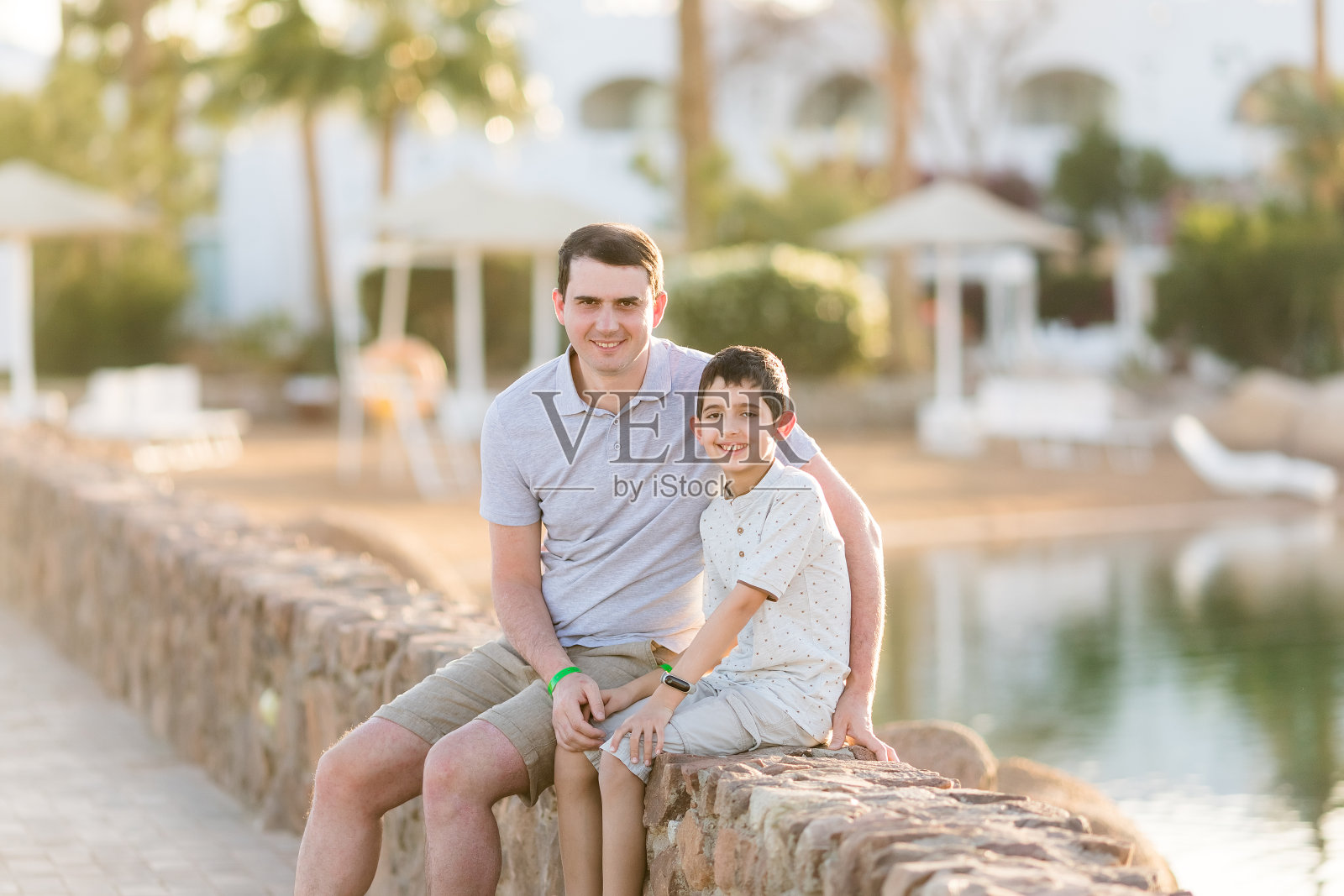 父子在湖边沙滩上，父亲节家庭度假照片摄影图片