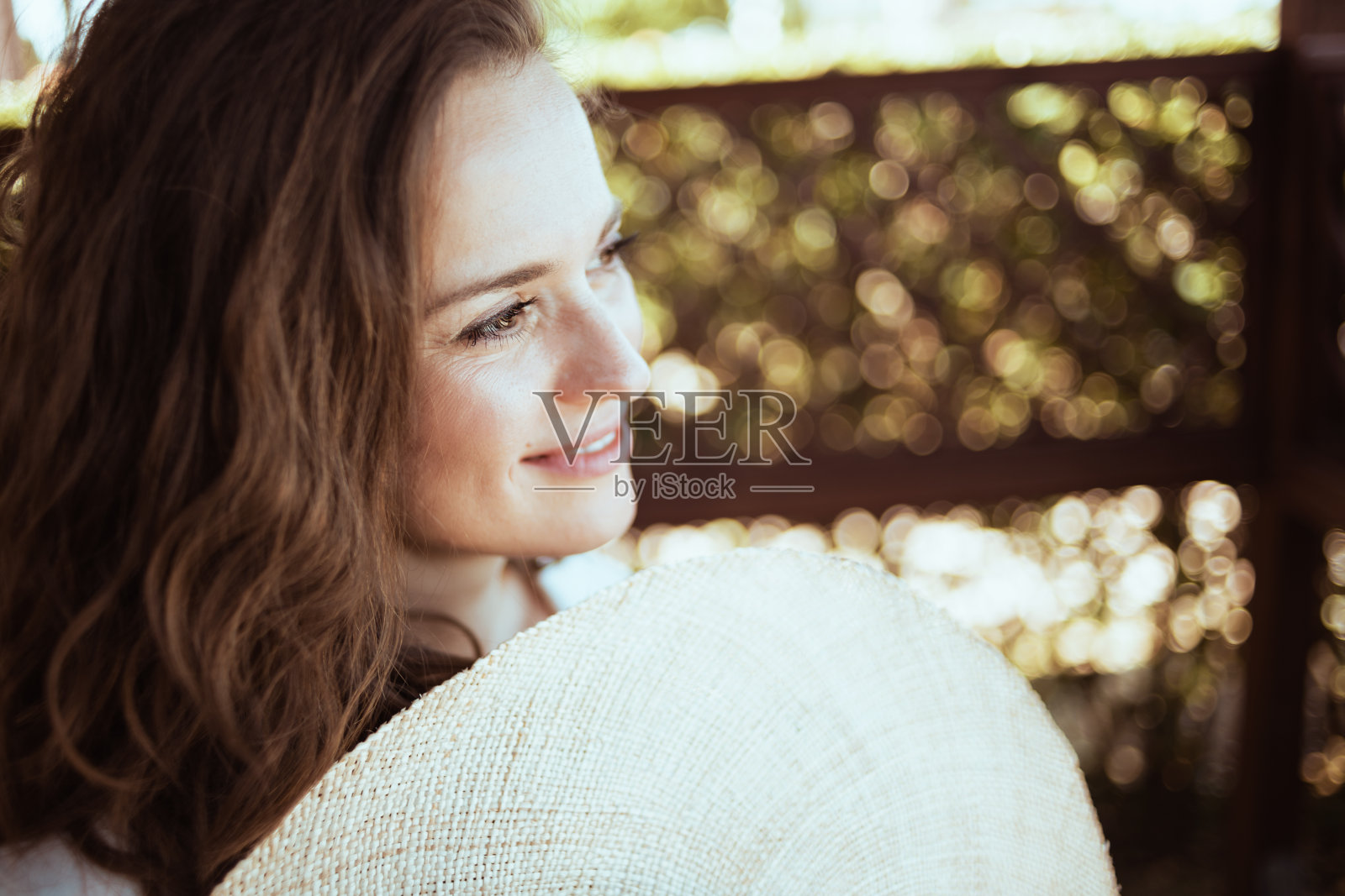 快乐新潮的家庭主妇在白色衬衫与帽子在露台照片摄影图片