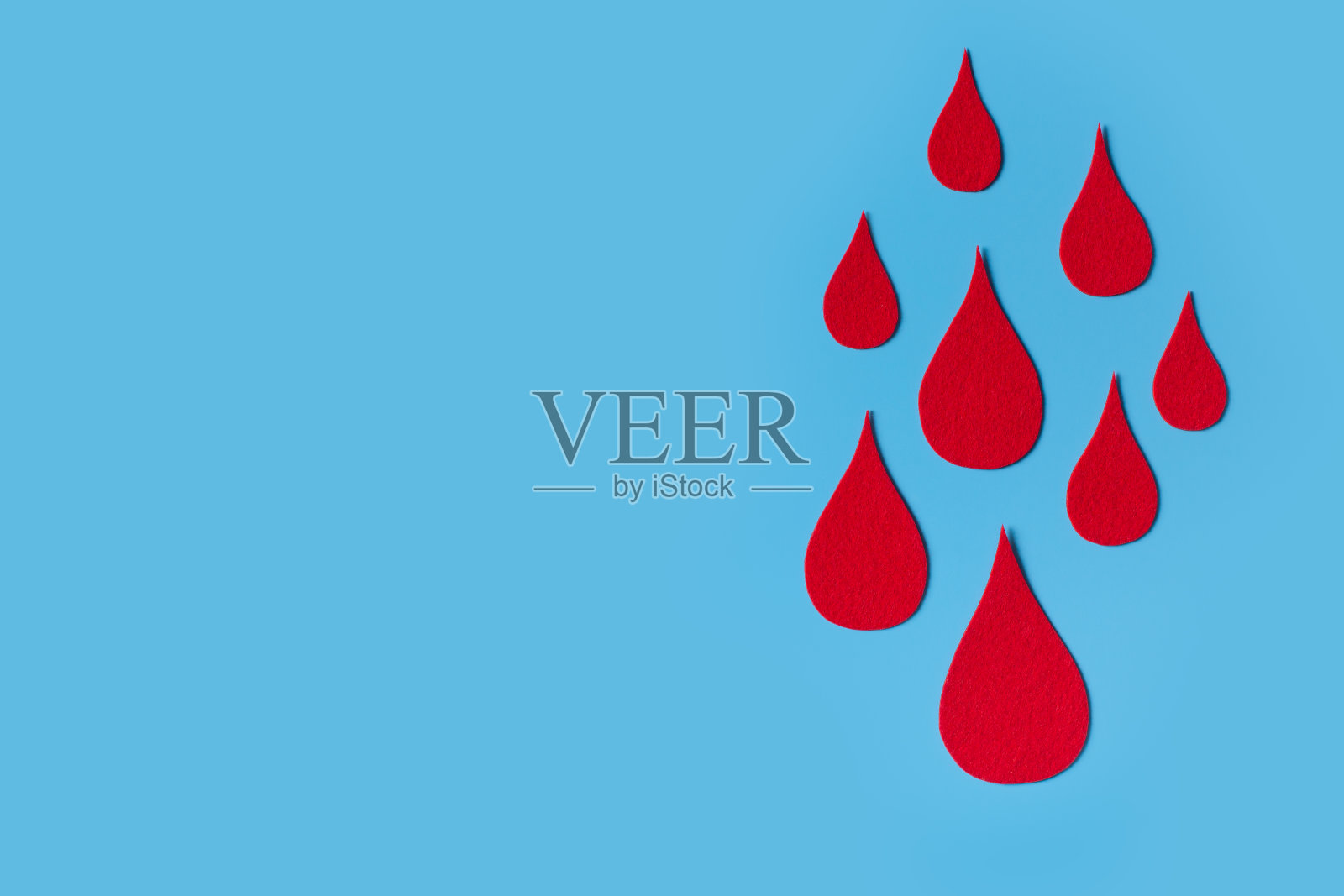 世界血友病日概念与红色血滴象征在蓝色的背景照片摄影图片