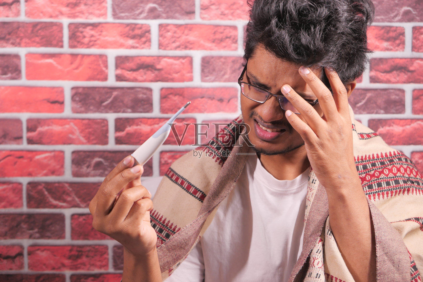 年轻男子手持数字温度计正在检查温度计照片摄影图片