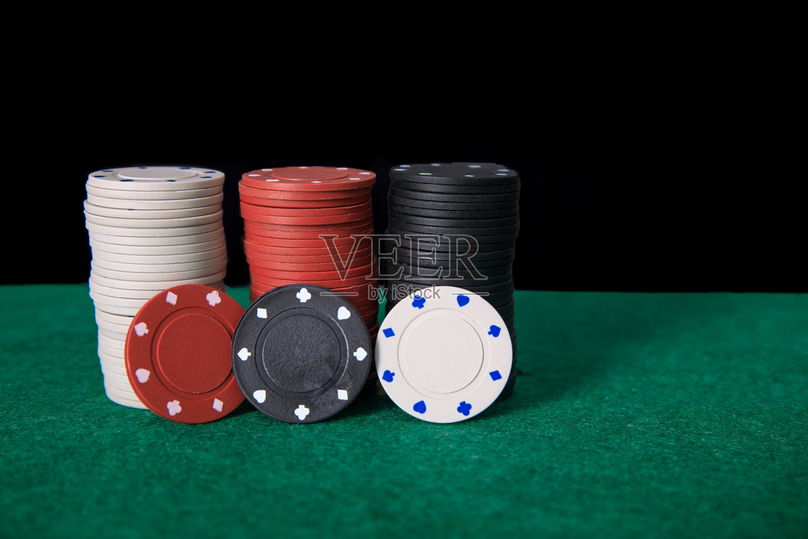 扑克筹码堆在绿色的扑克桌上照片摄影图片