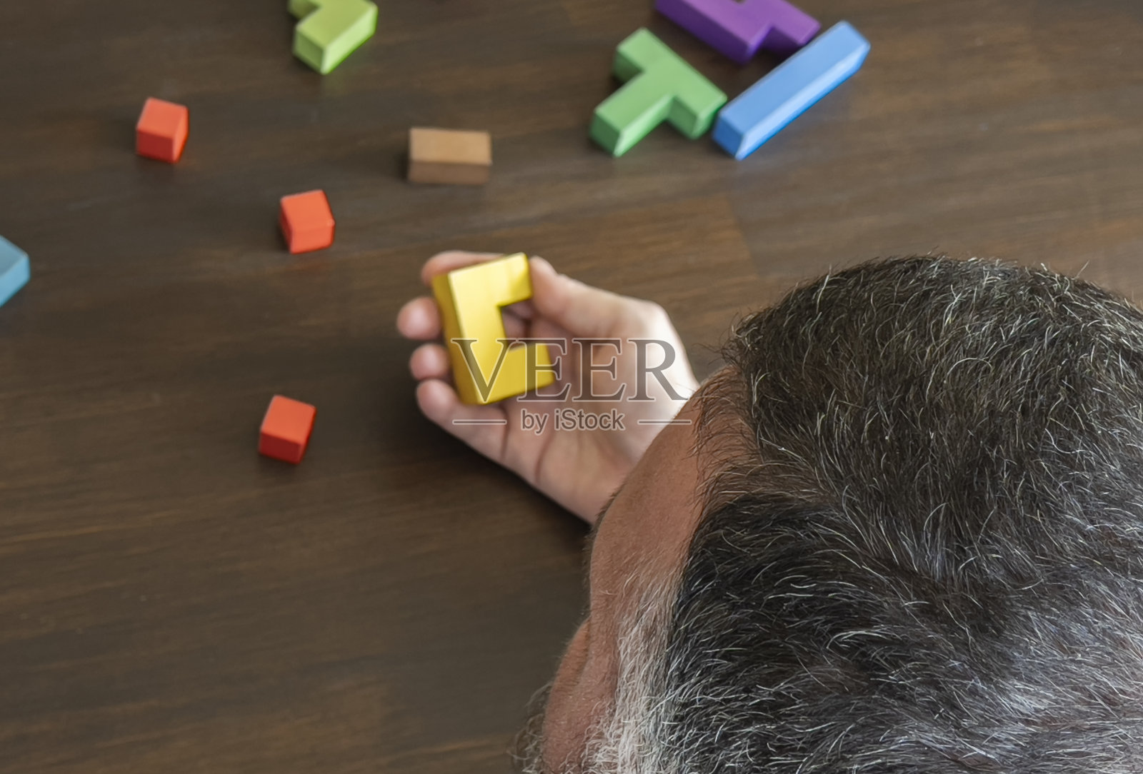 玩木制拼图的男人照片摄影图片