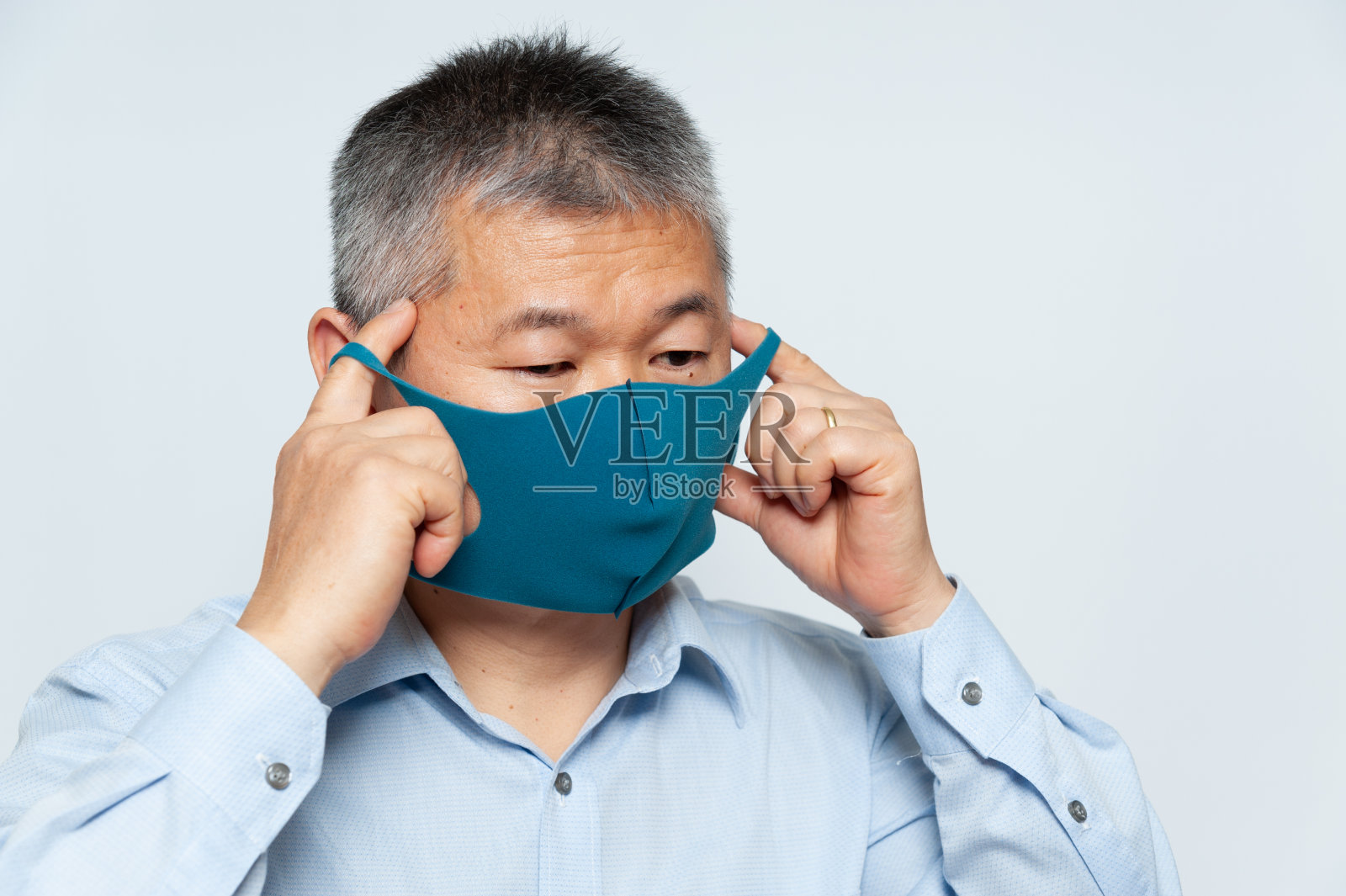 亚洲中年男子佩戴可重复使用的聚氨酯口罩，以预防Covid-19。在白色背景上隔离照片摄影图片