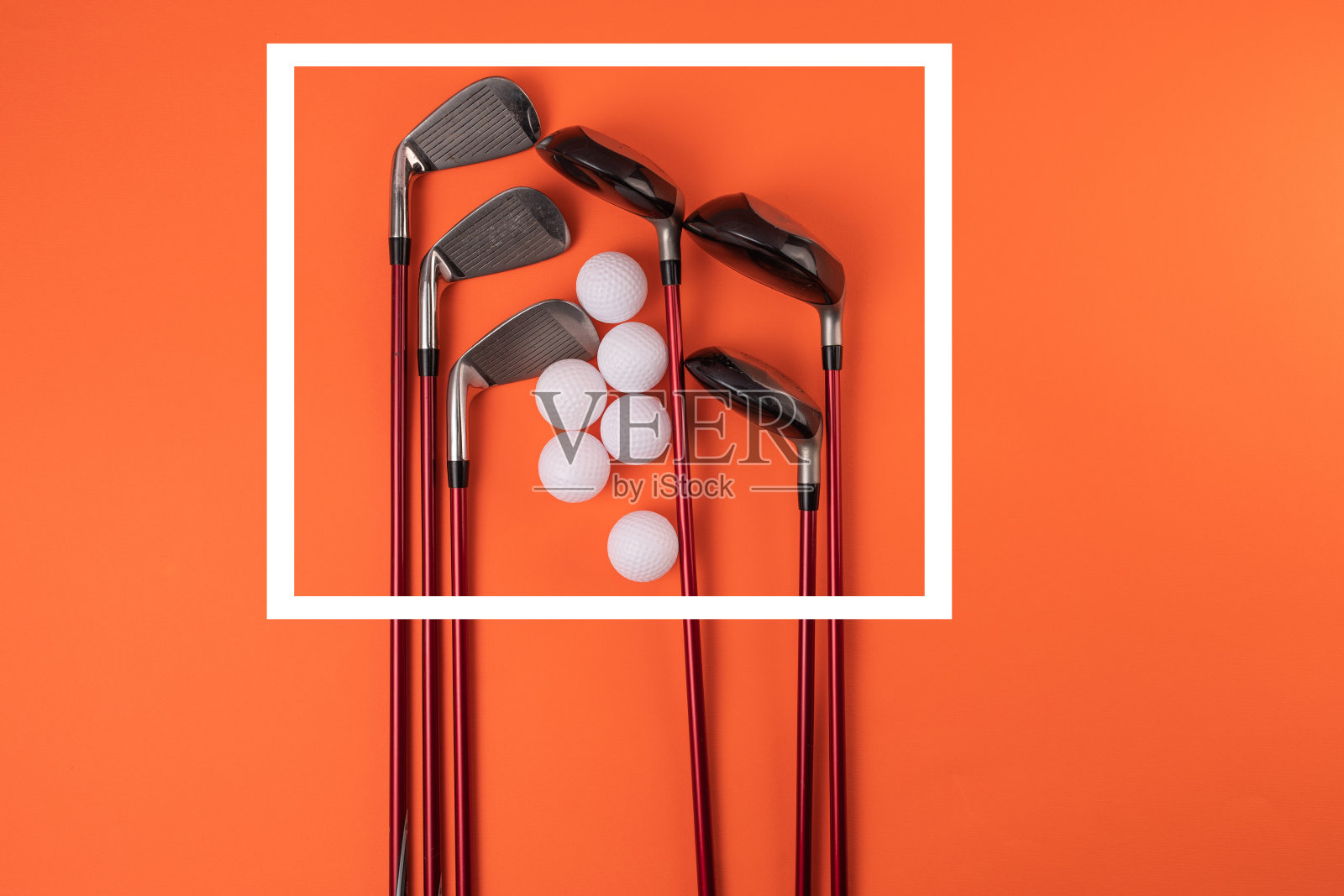 橙色背景上的高尔夫球杆和高尔夫球照片摄影图片