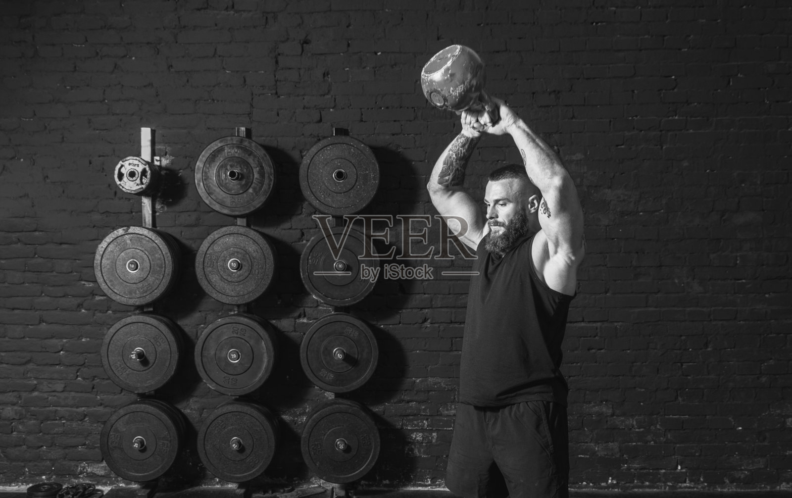 年轻活跃的出汗的肌肉强壮的健康的人与大肌肉做硬核壶铃摆动锻炼交叉训练在健身房真实的人锻炼照片摄影图片