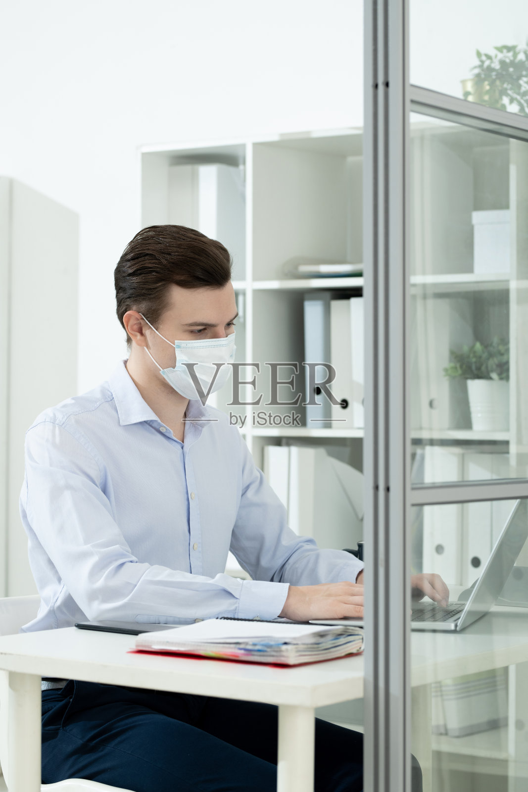 年轻商人戴着防护面具和正装在办公室交际照片摄影图片