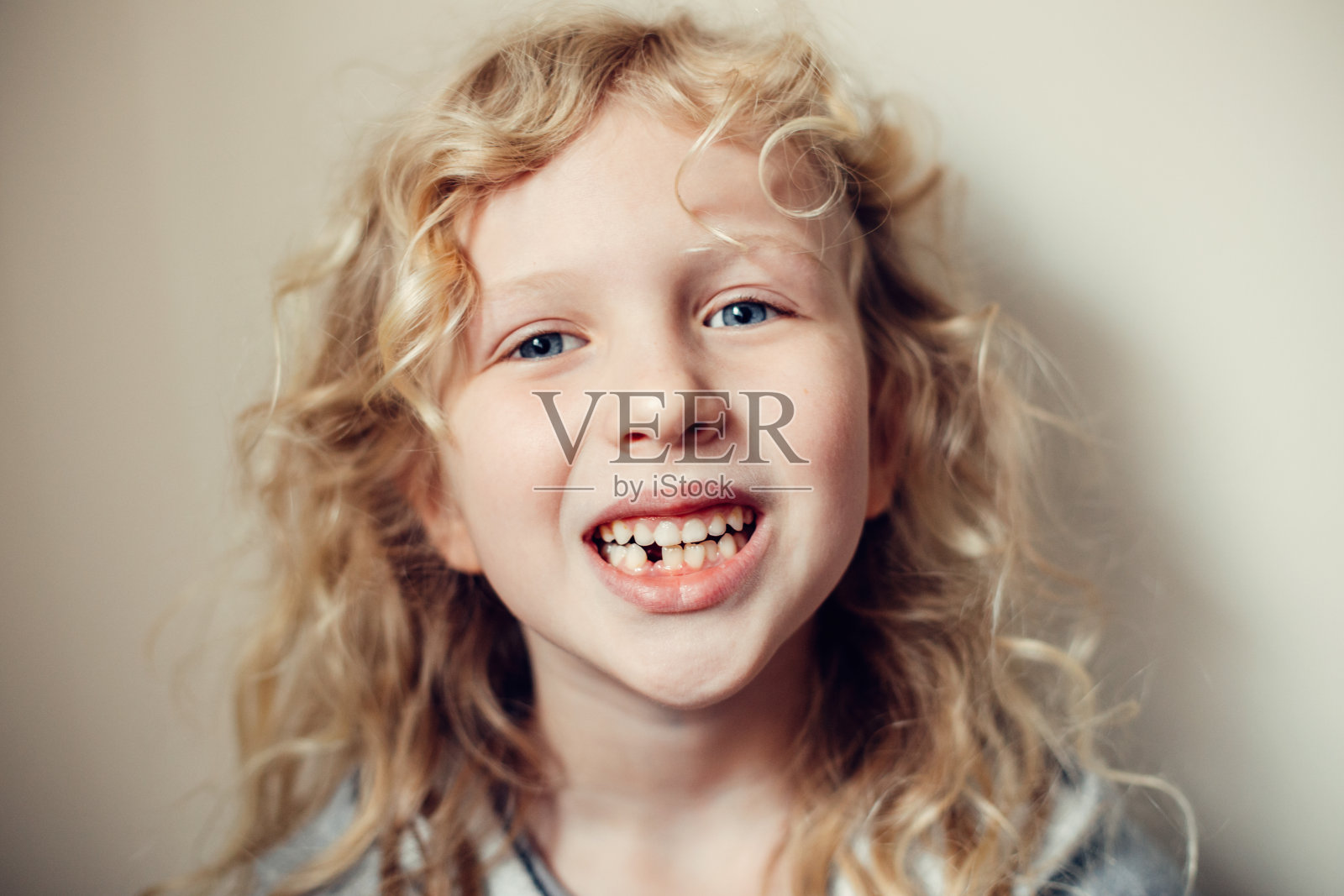 微笑的白人金发女孩的特写显示她丢失的乳牙。口腔卫生。儿童成长阶段和青春期。快乐真实的童年生活方式。照片摄影图片