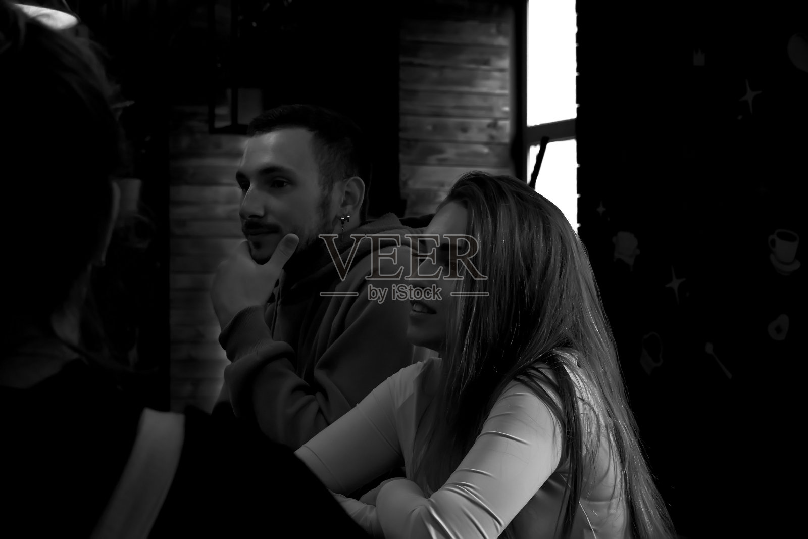 一个男孩和一个女孩坐在黑暗的酒吧里照片摄影图片