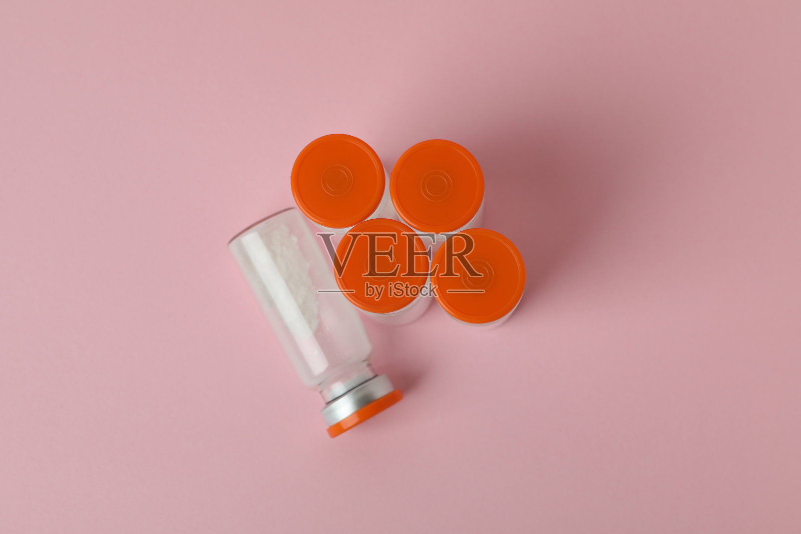 粉末状疫苗的小瓶，背景为粉红色照片摄影图片